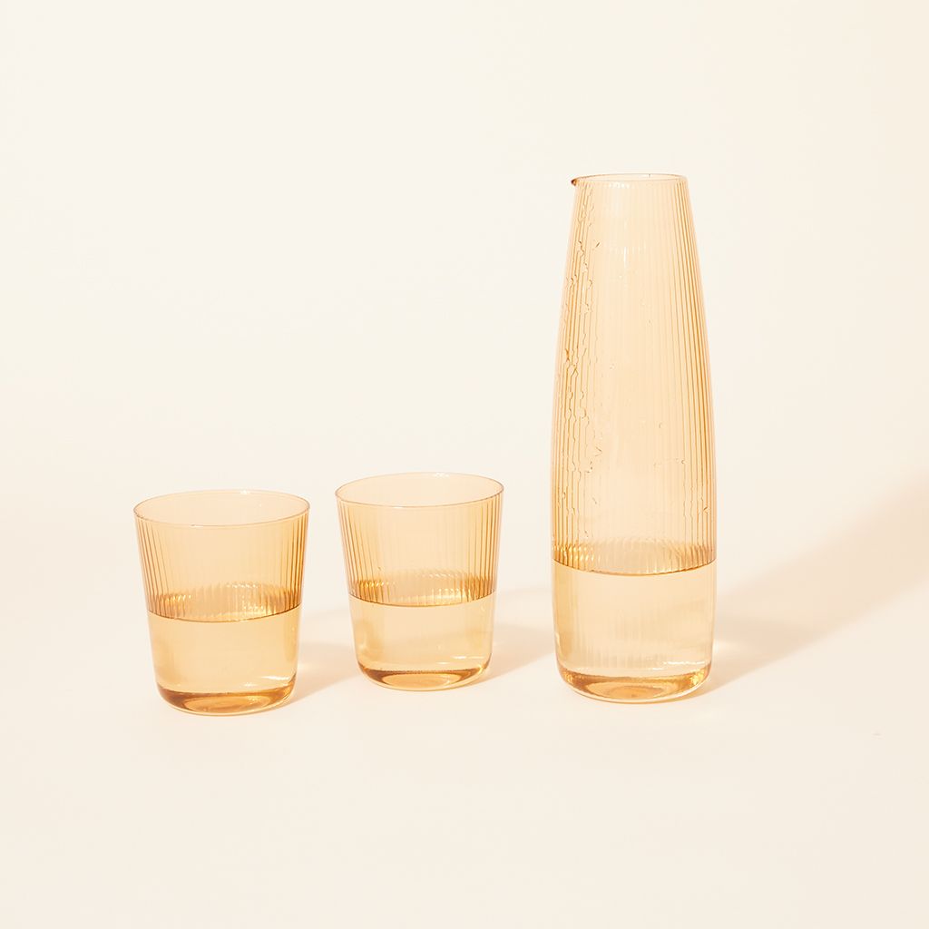 Two pale yellow drinking glasses with matching carafe
