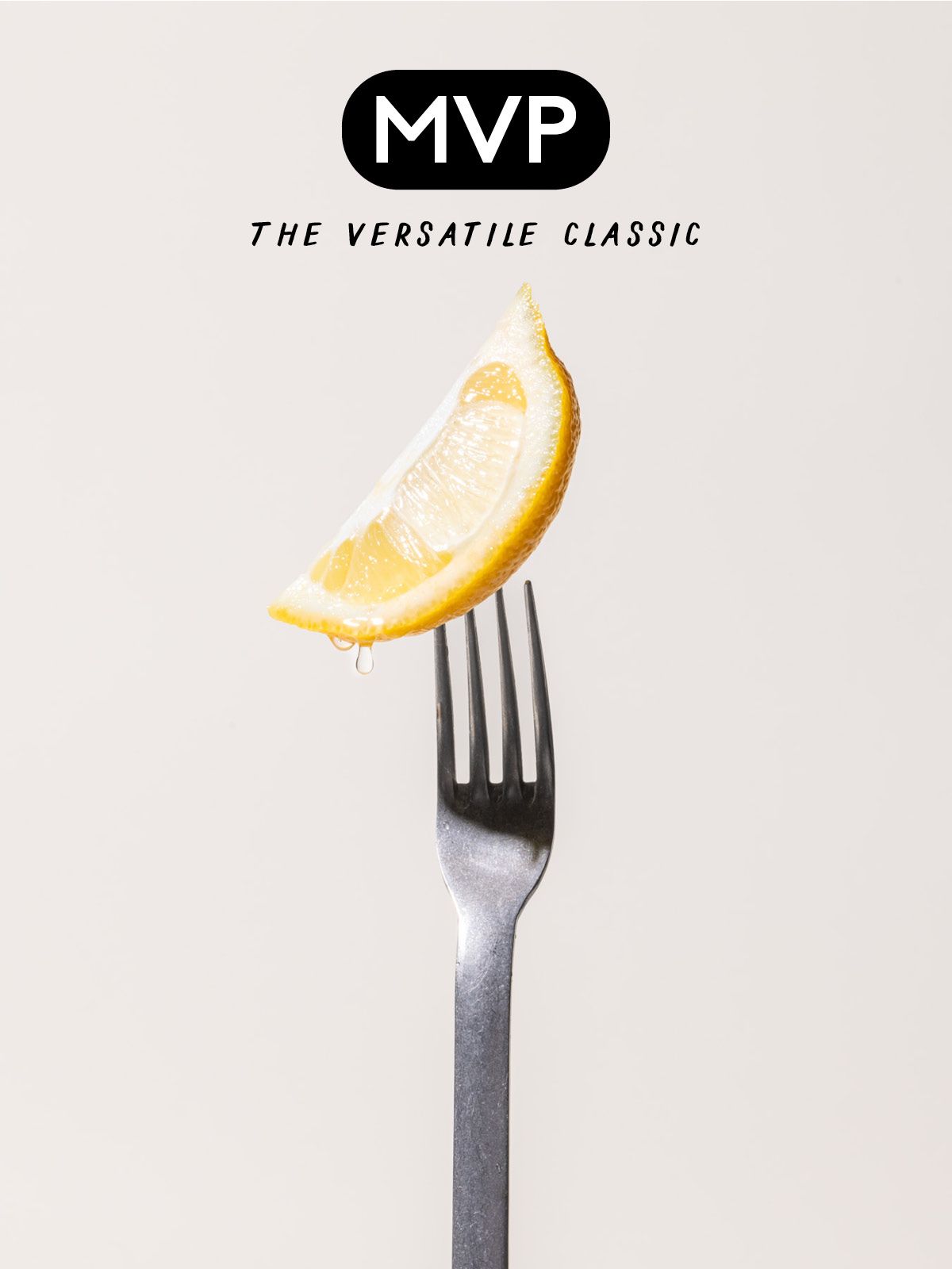 A stainless steel fork with a lemon wedge on the prongs with text that reads "MVP - The Versatile Classic"