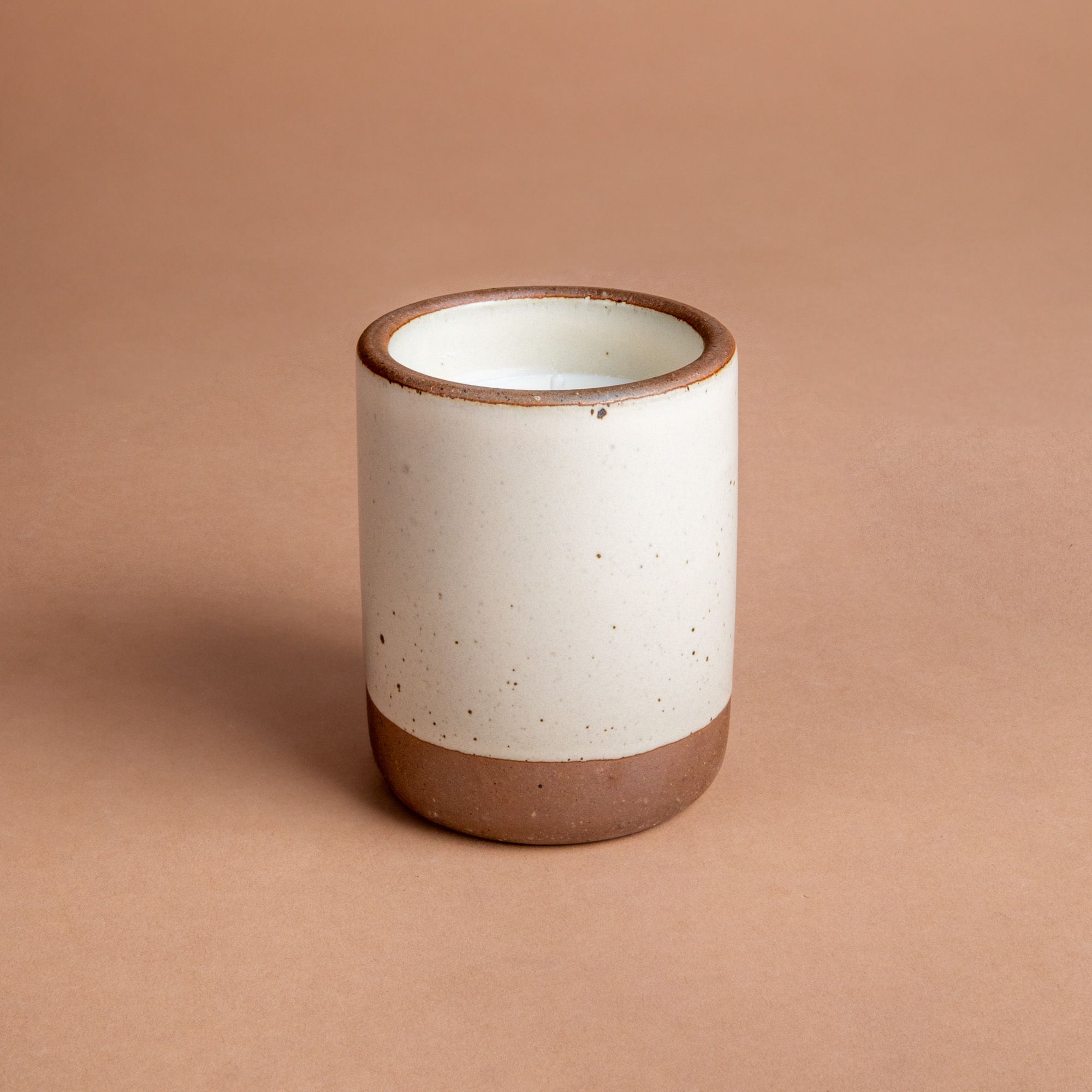 Large ceramic vessel in a warm off-white color with candle inside.