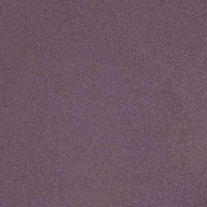 A closeup of a ceramic plate in a purple color with a soft, glowing sheen and iron speckles throughout