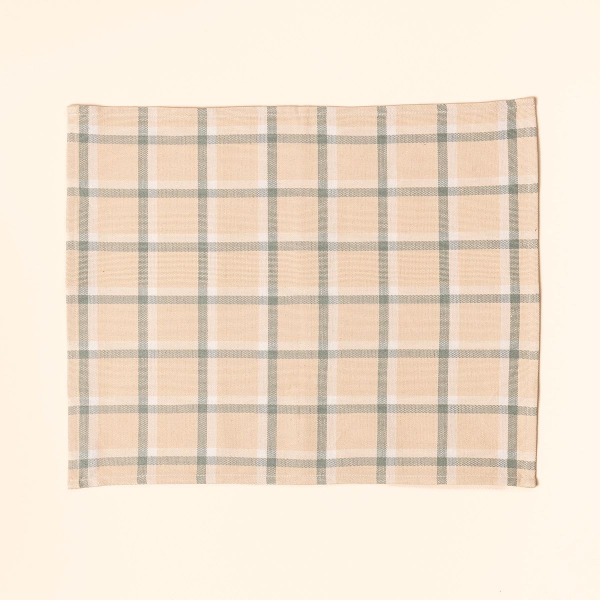 A gingham rectangular placemat in cream, off-white, and sage green colors