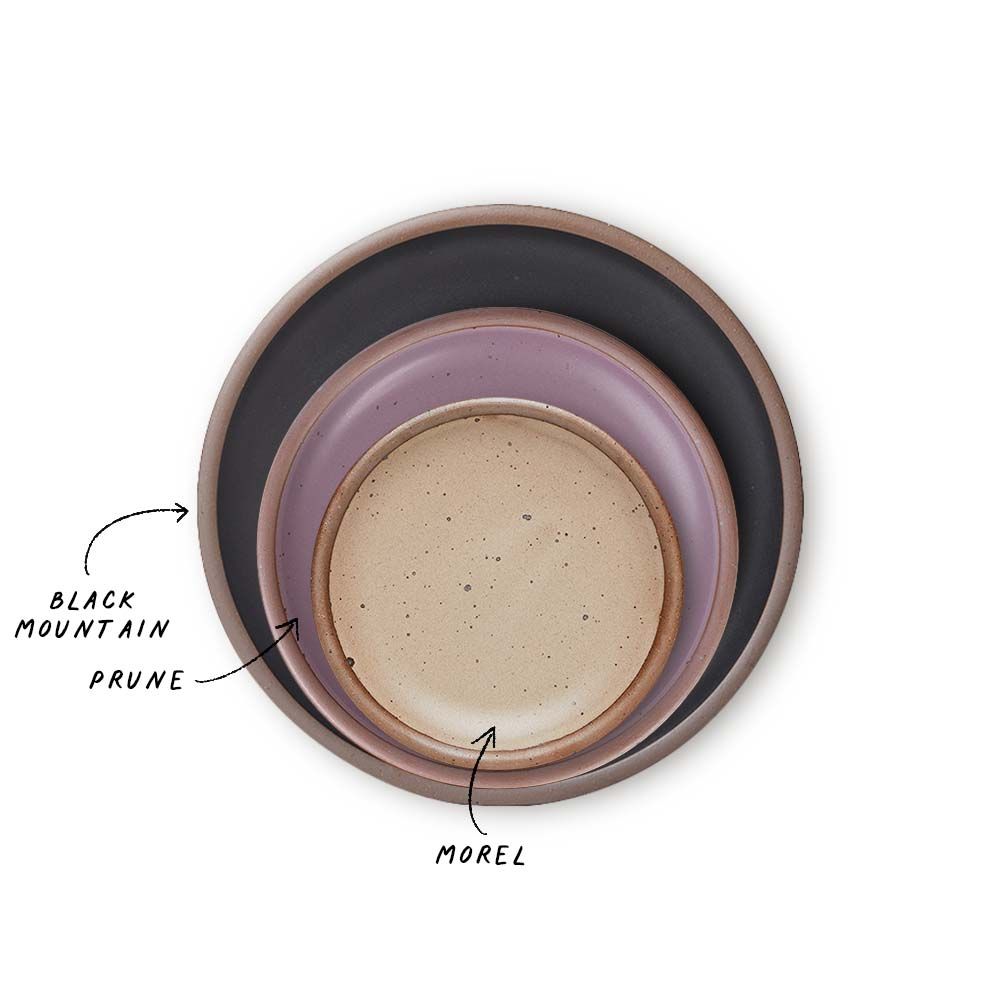 A stack of 3 plates in Dinner, Side, and Cake sizes in a black, soft mauve purple, and warm pale brown colors.
