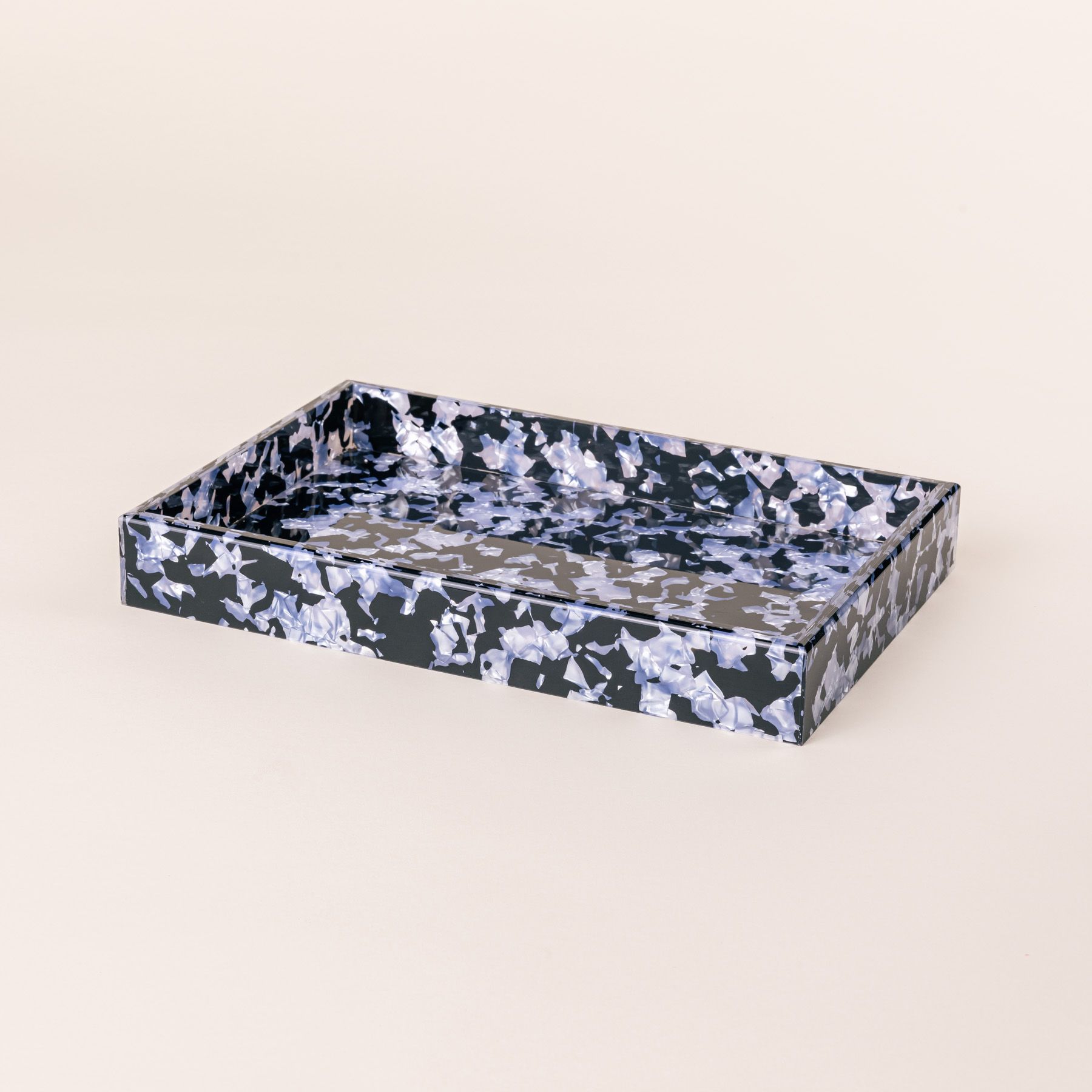 A rectangular acrylic tray with a black and light blue granite-like design