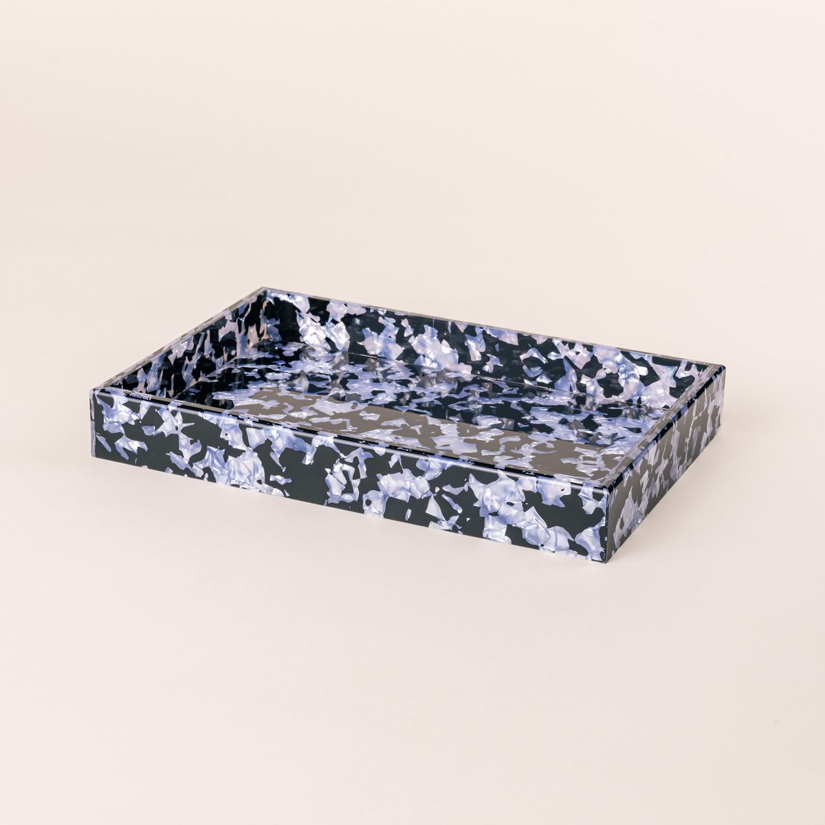 A rectangular acrylic tray with a black and light blue granite-like design