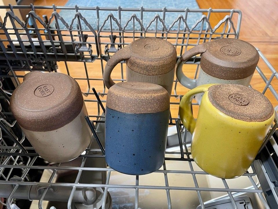 A collection of of East Fork Mugs in a dishwasher.