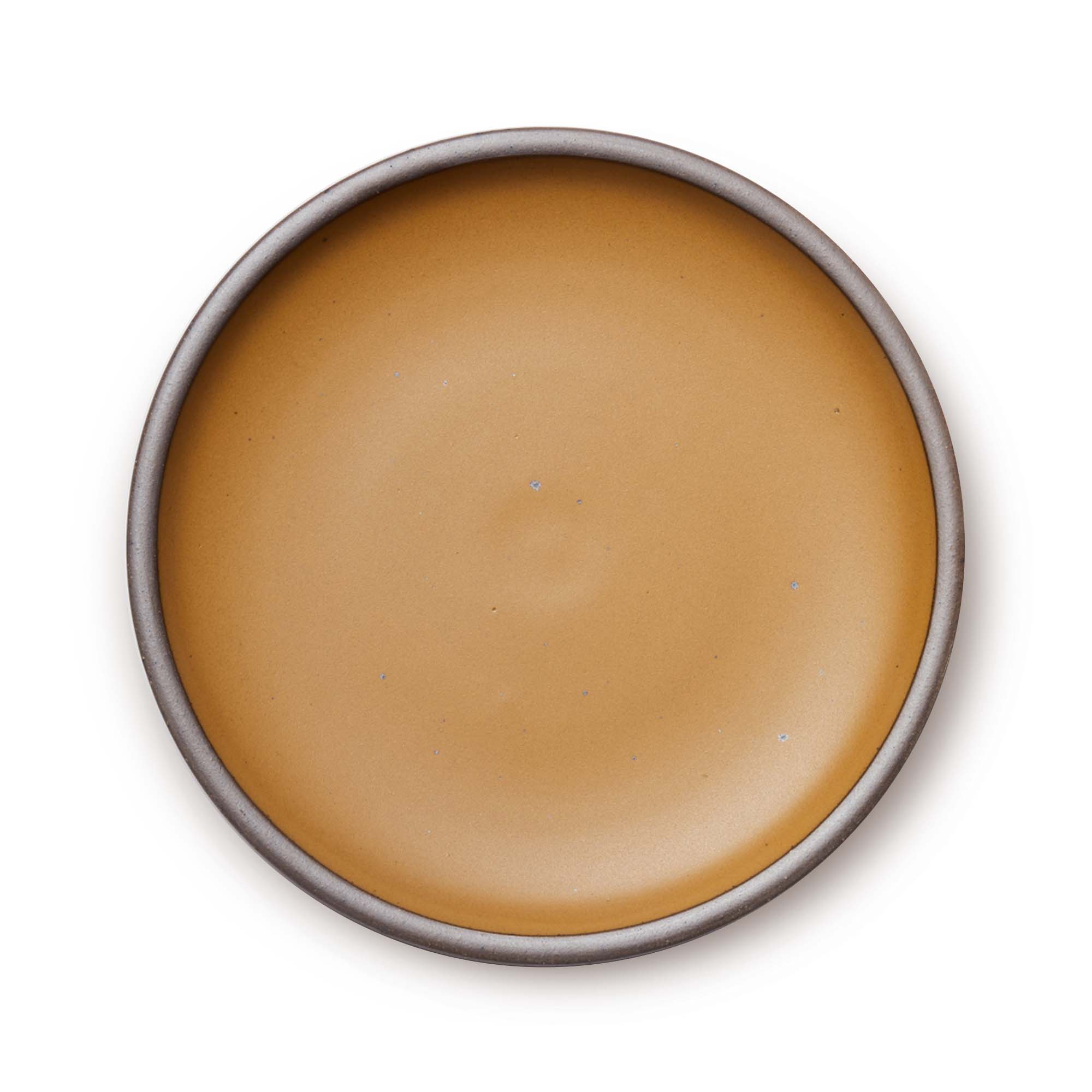 A large ceramic platter in a dark gold color featuring iron speckles and an unglazed rim.