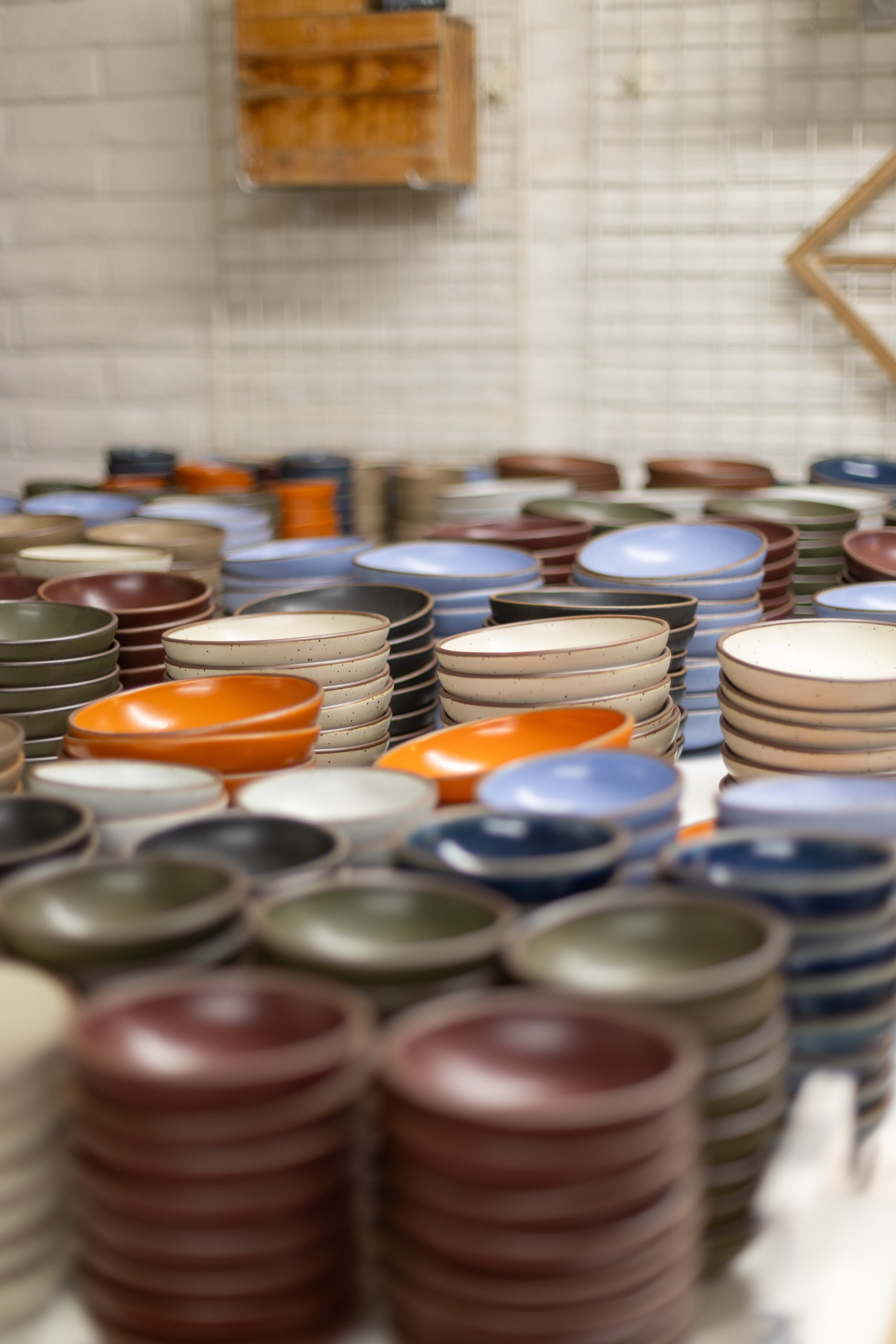 Indoors, there are large tall stacks of ceramic bowls in all different colors of the rainbow