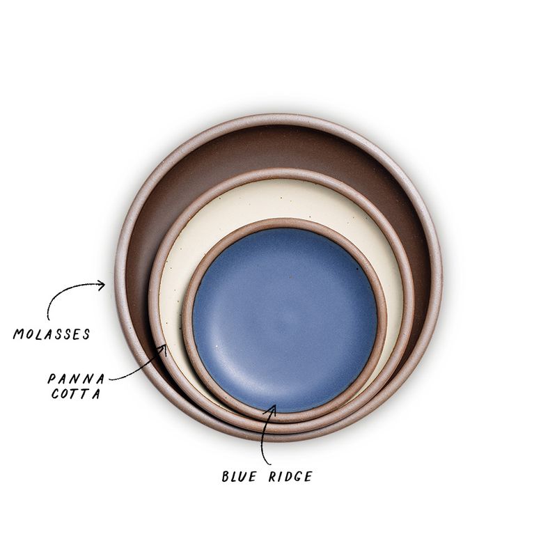 A stack of 3 plates in Dinner, Side, and Cake sizes in a dark brown, warm off-white, and navy colors.