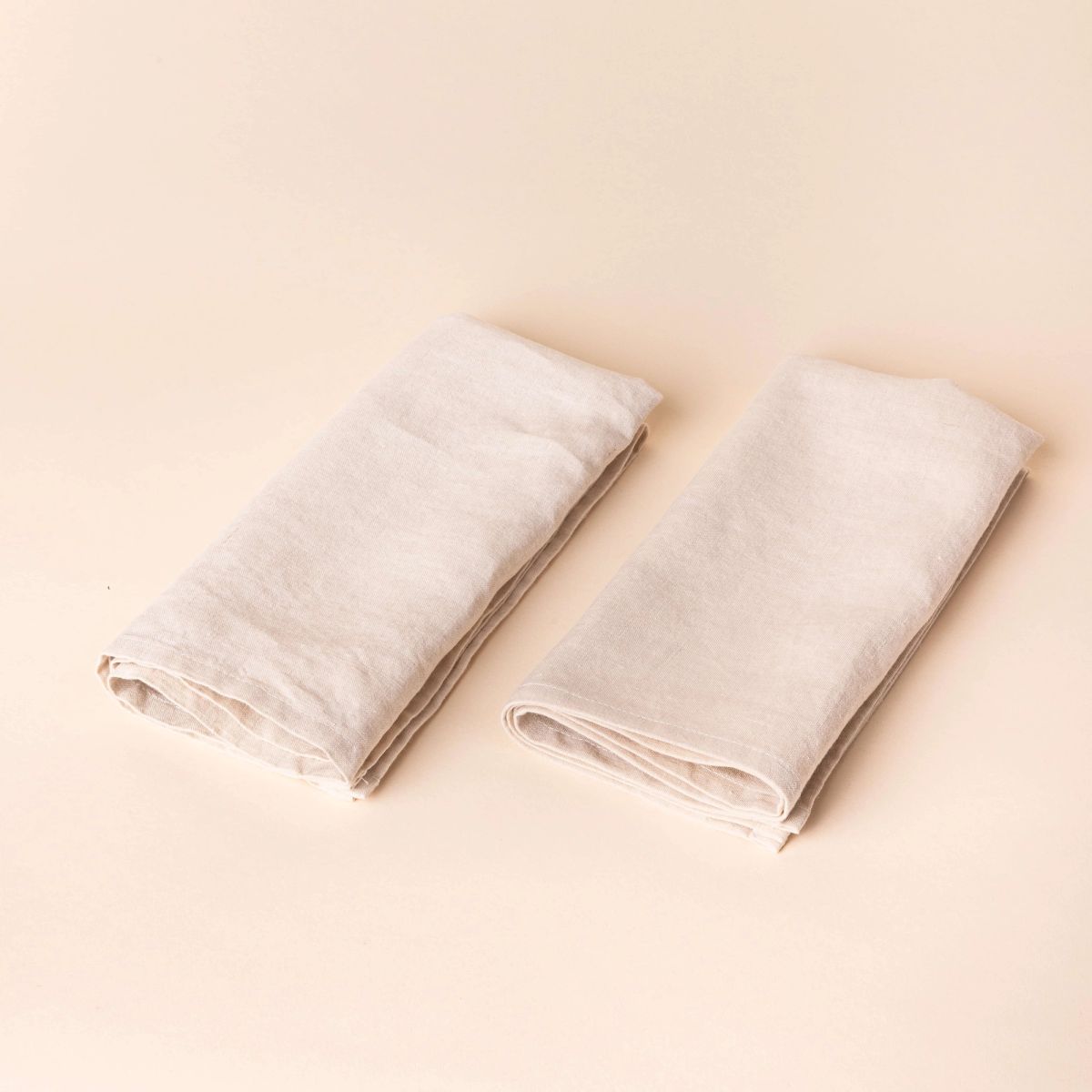 Two off-white napkins folded into rectangles side by side
