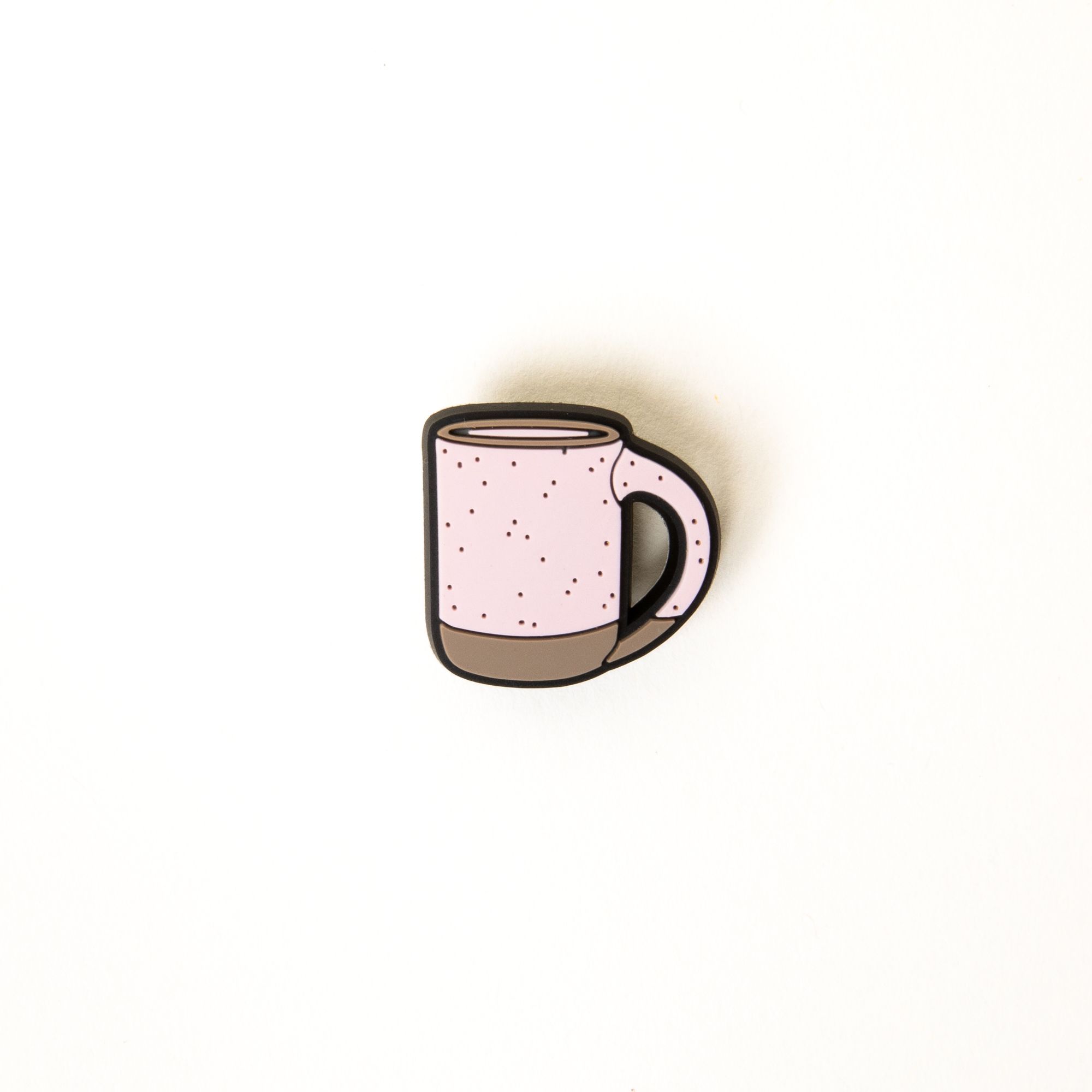 A small soft light pink and brown plastic charm shaped like an East Fork Mug for your plastic clogs called Crocs