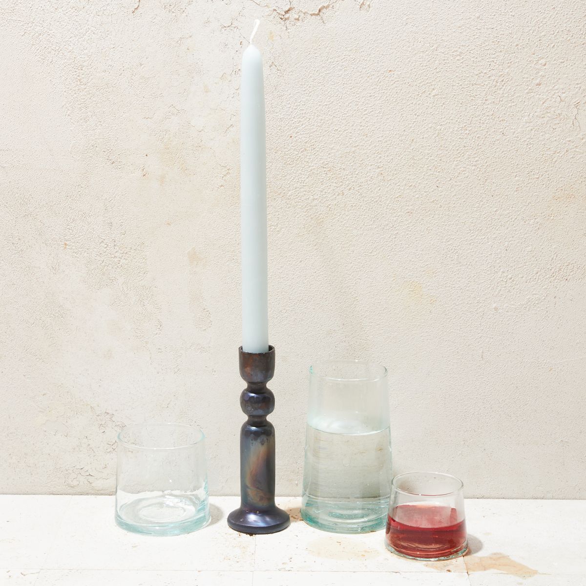 Iron Urbino Candlestick with candle in it surrounded by glasses