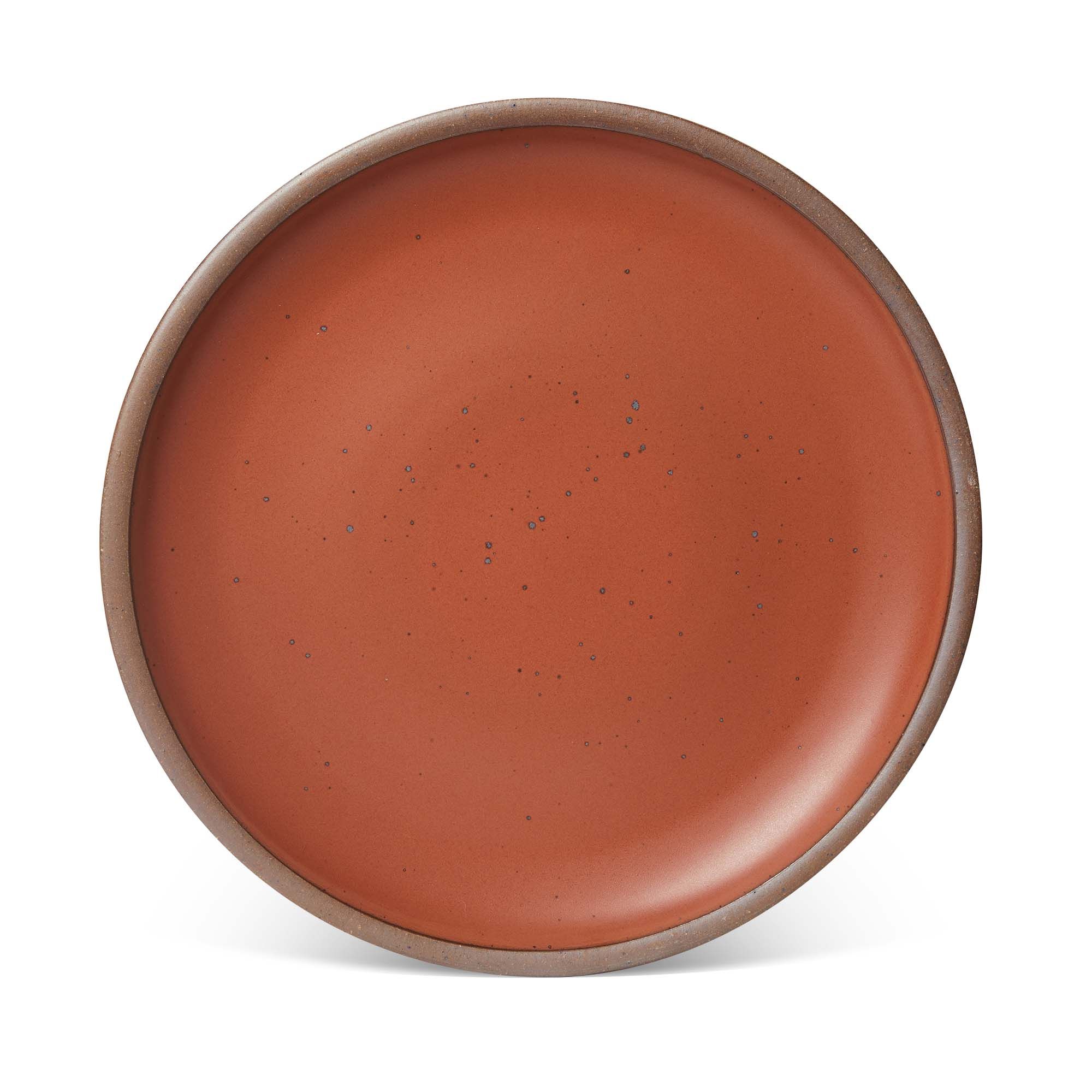 A large ceramic platter in a cool burnt terracotta color featuring iron speckles and an unglazed rim.
