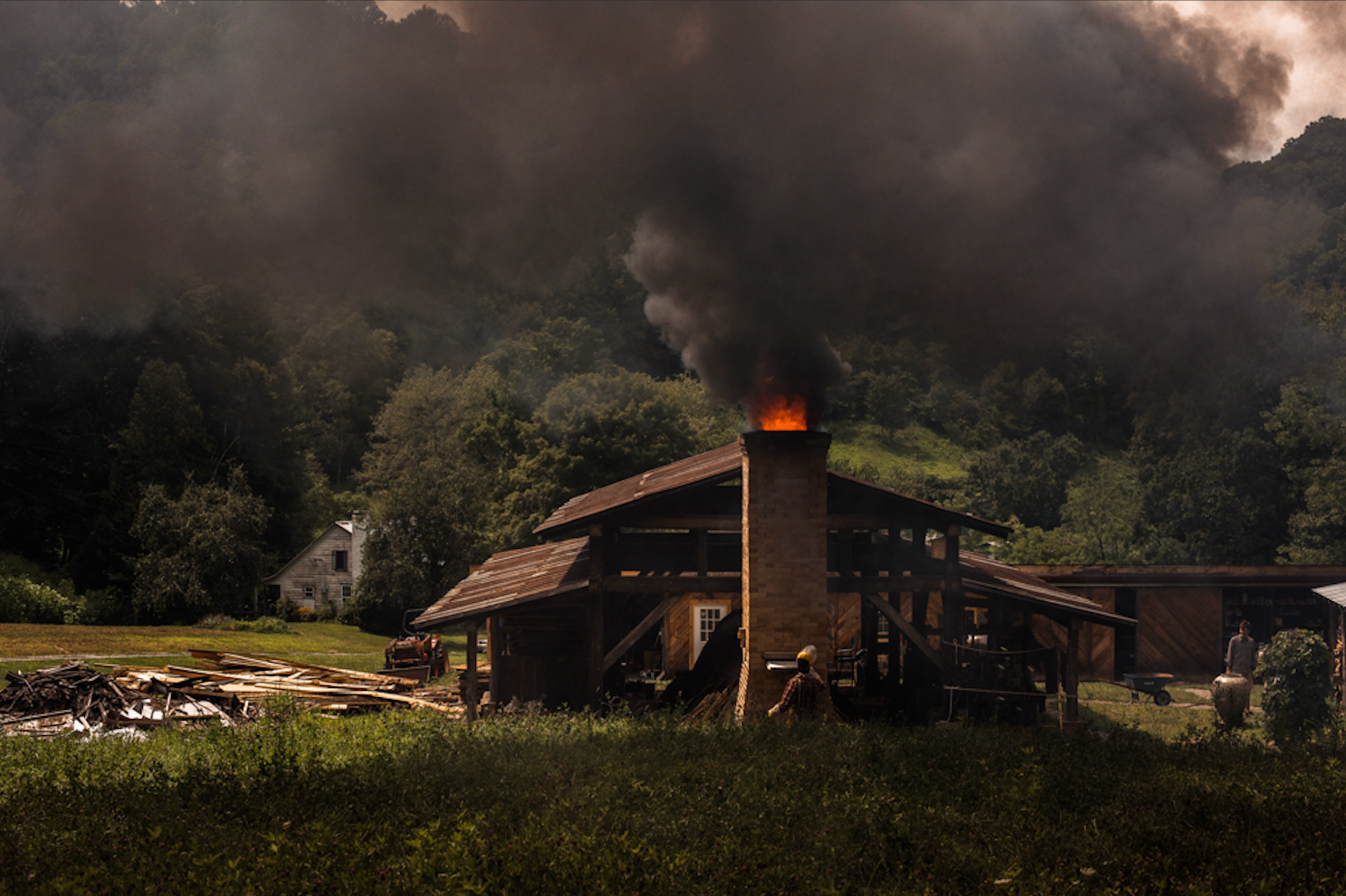 A photo of the old tobacco farm in Madison County North Carolina. Smoke billows out of the wood-fired kiln.