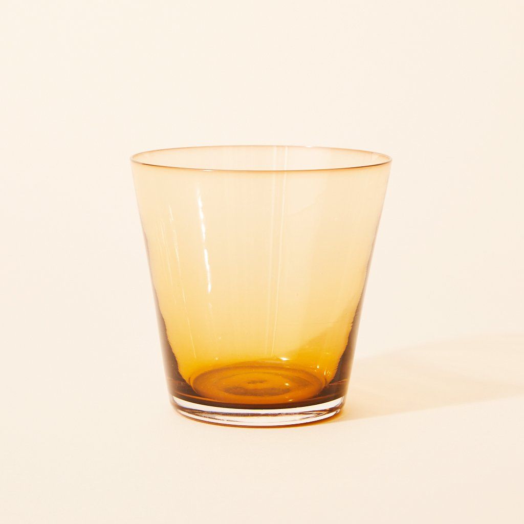 Amber glass drinking vessel that tapers from its flared rim