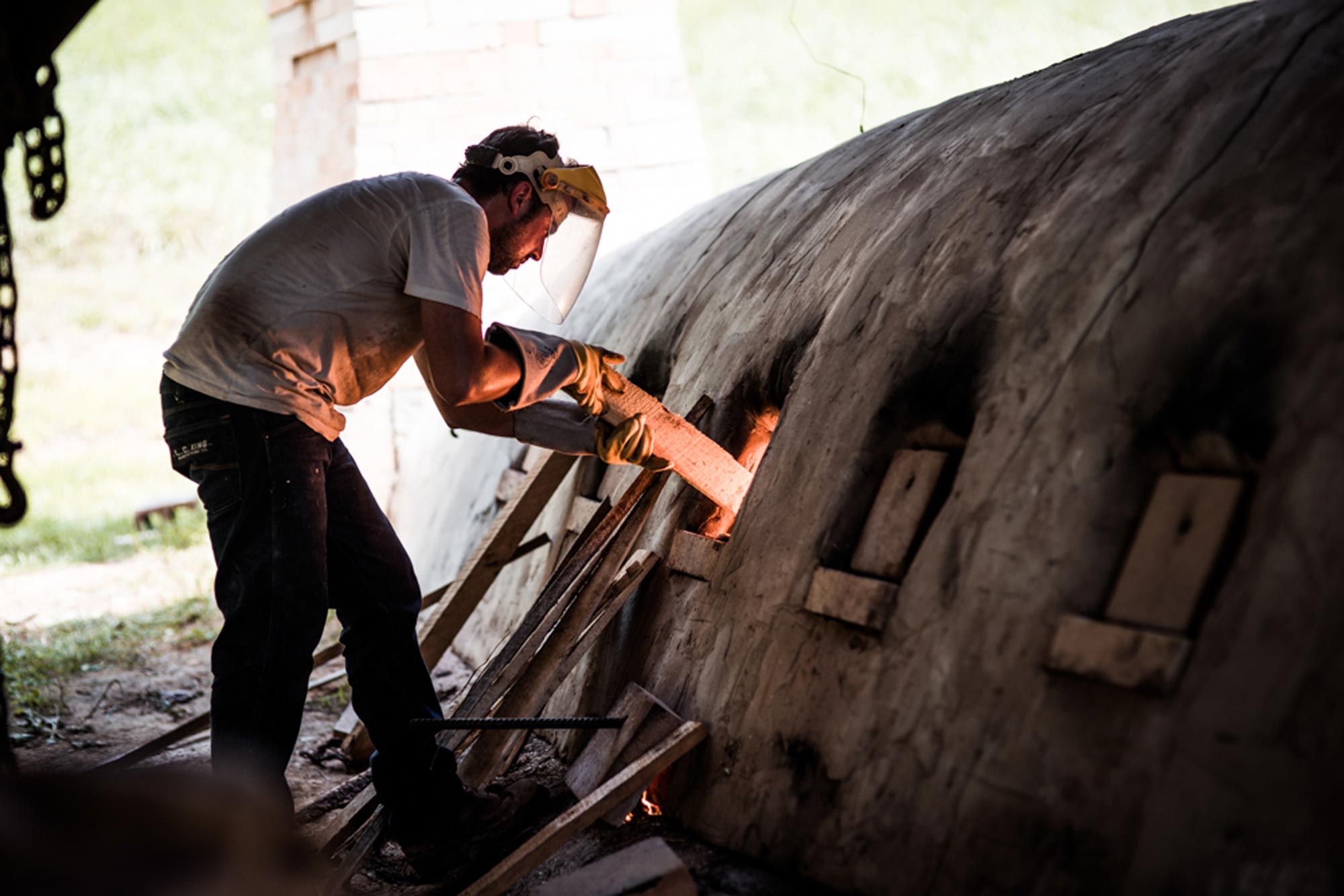 Alex Matisse loading wood into the kiln