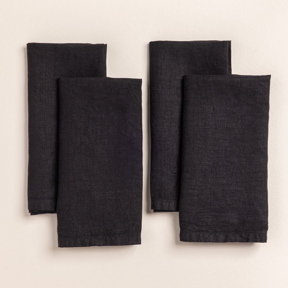 4 folded linen napkins in a black color