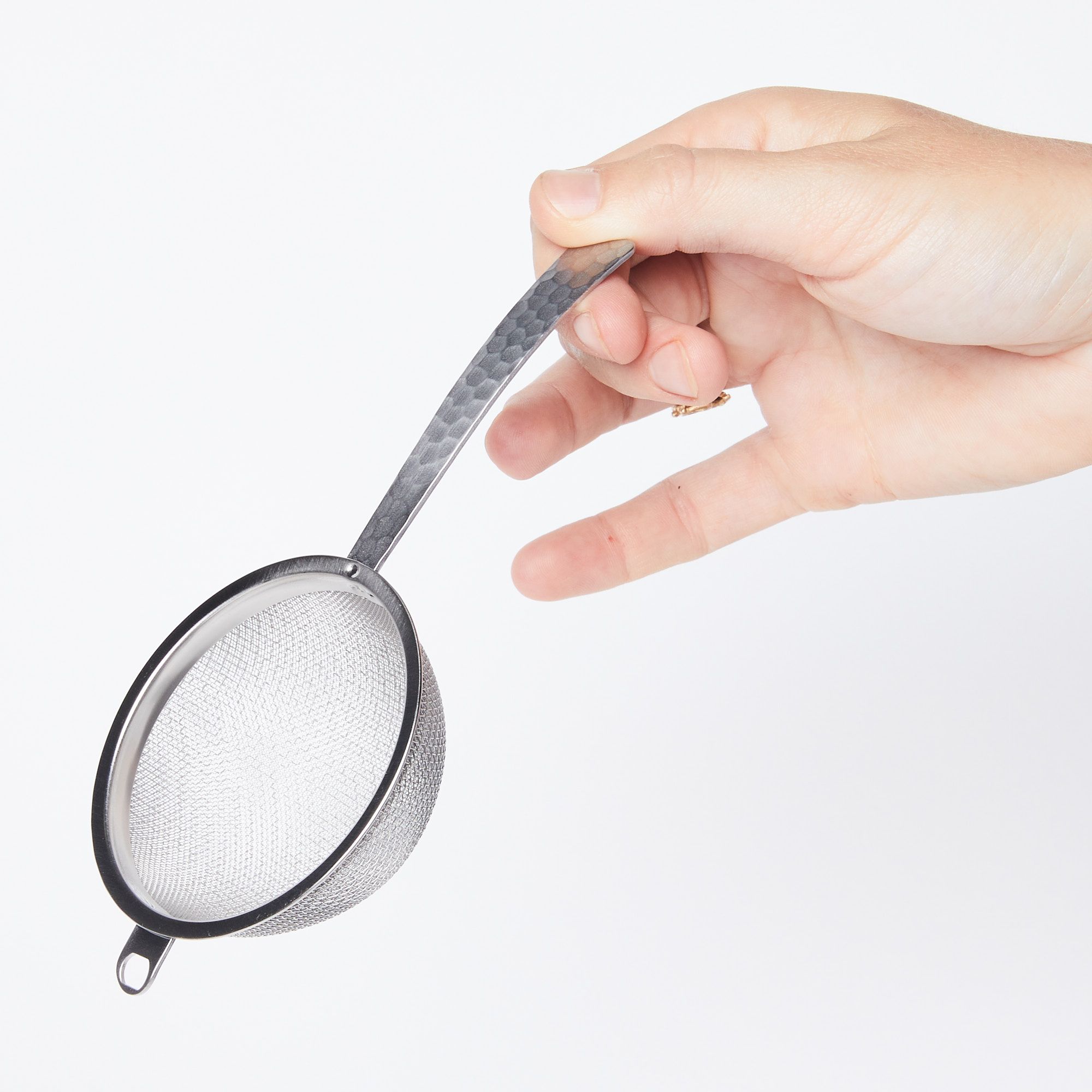 hand holding handle of Stainless steel half dome strainer with steel handle