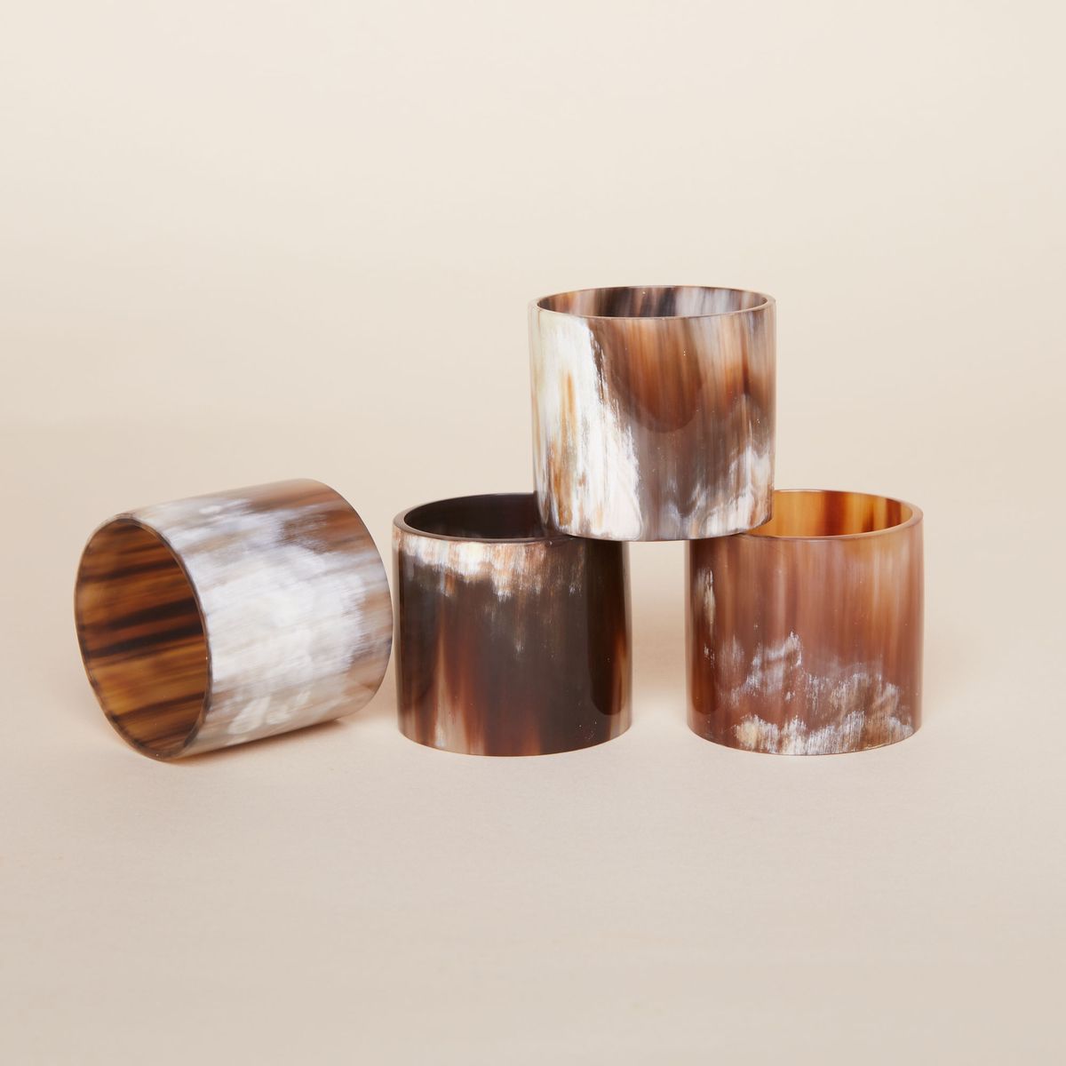 Four water buffalo horn napkin rings in shades of brown and white 