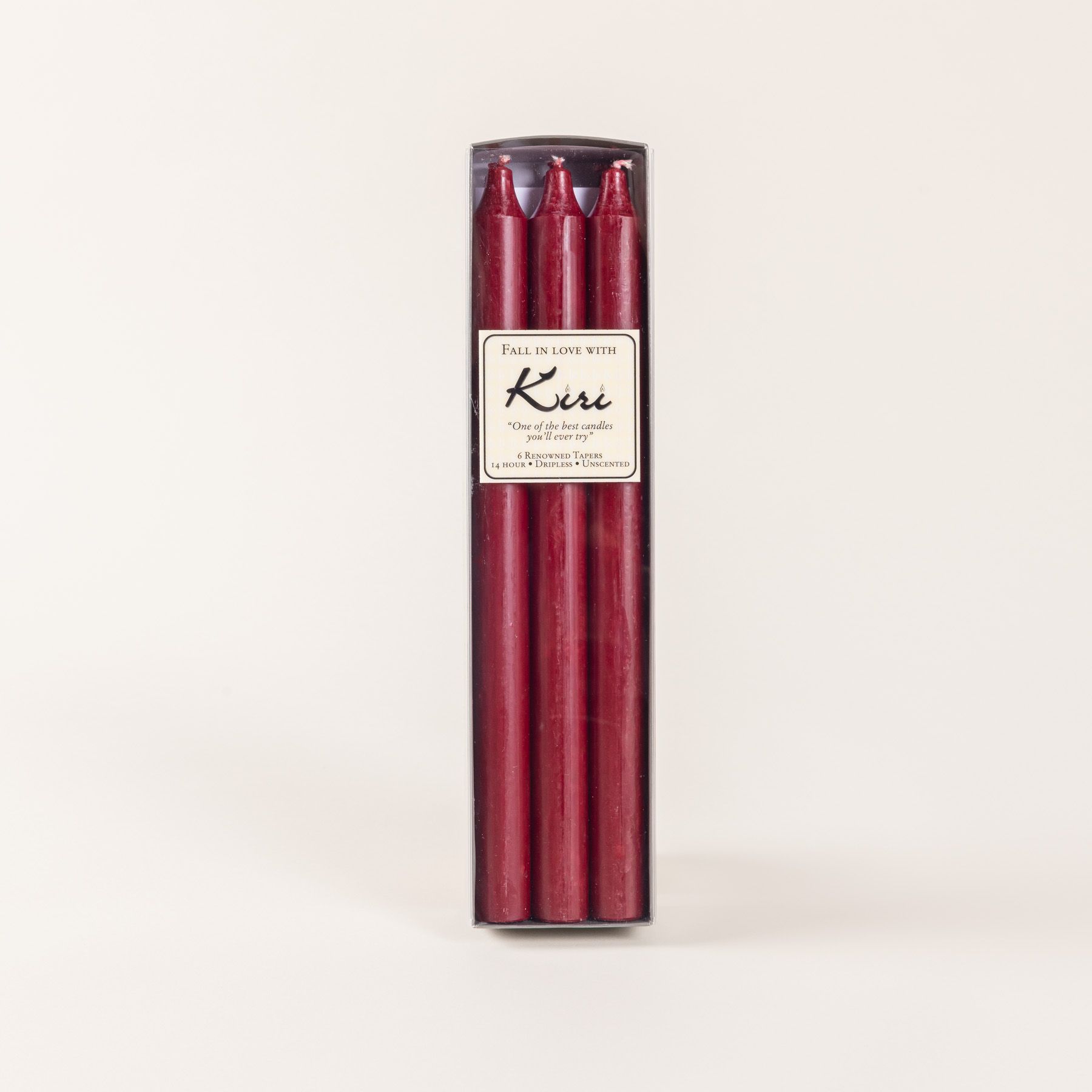 A narrow box of dark red taper candles with a cream label.