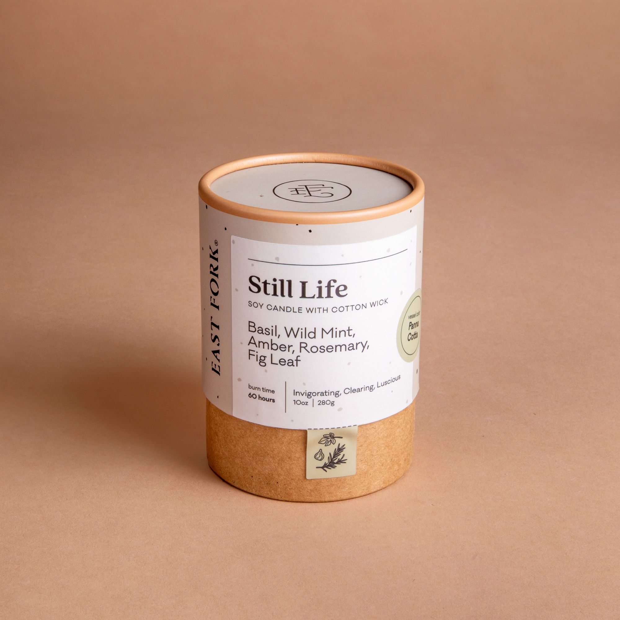 Large cardboard packaging tube with a candle inside with branding on it that says 'Still Life'