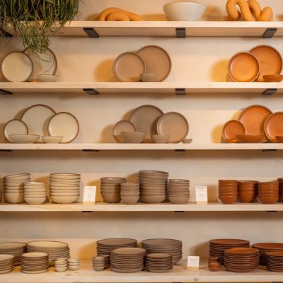 The pottery set wall in East Fork's store in Asheville featuring ceramic dinnerware in off-white, pale warm brown, and terracotta colors.