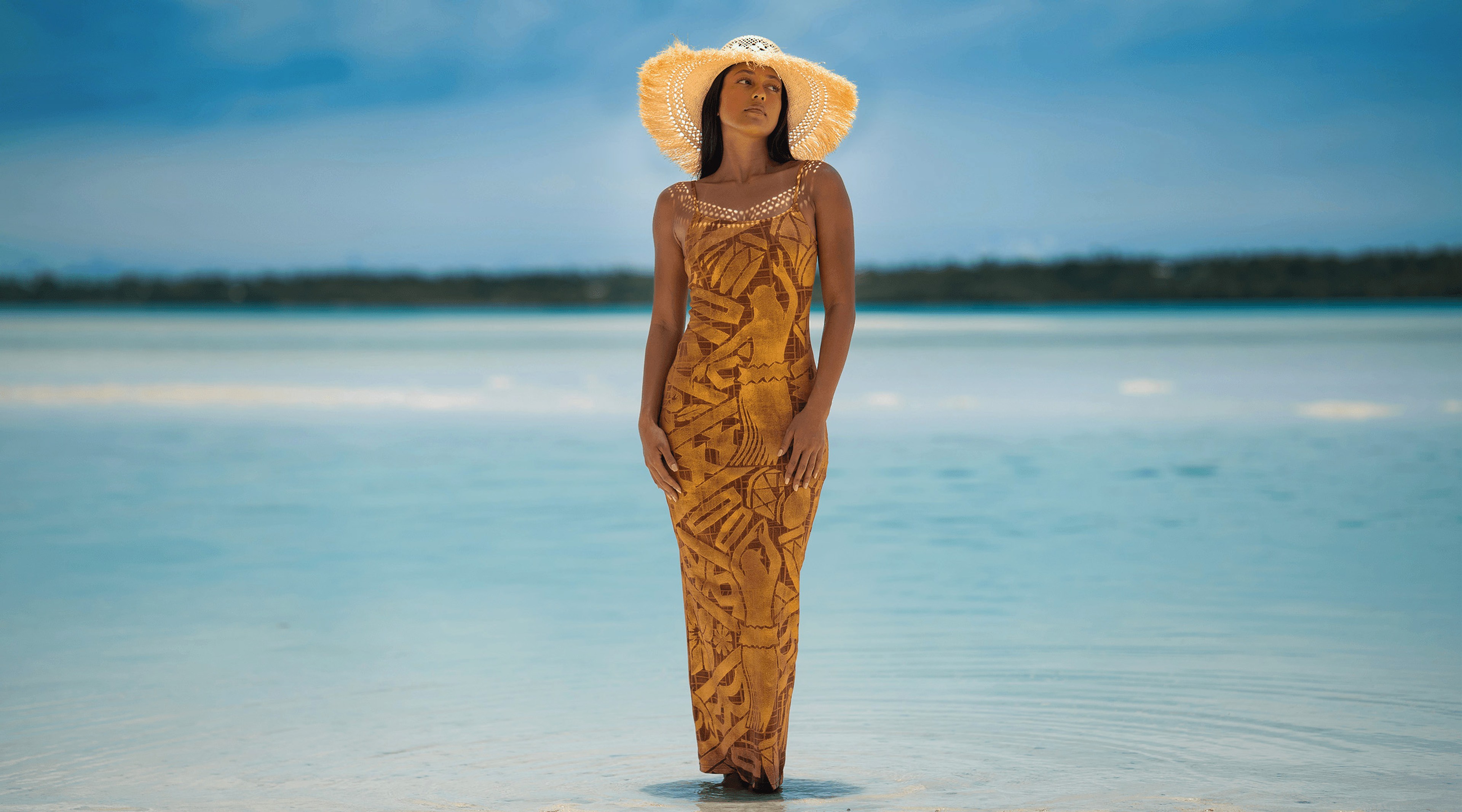 Woman wearing a gold dress, standing in the middle of the lagoon
