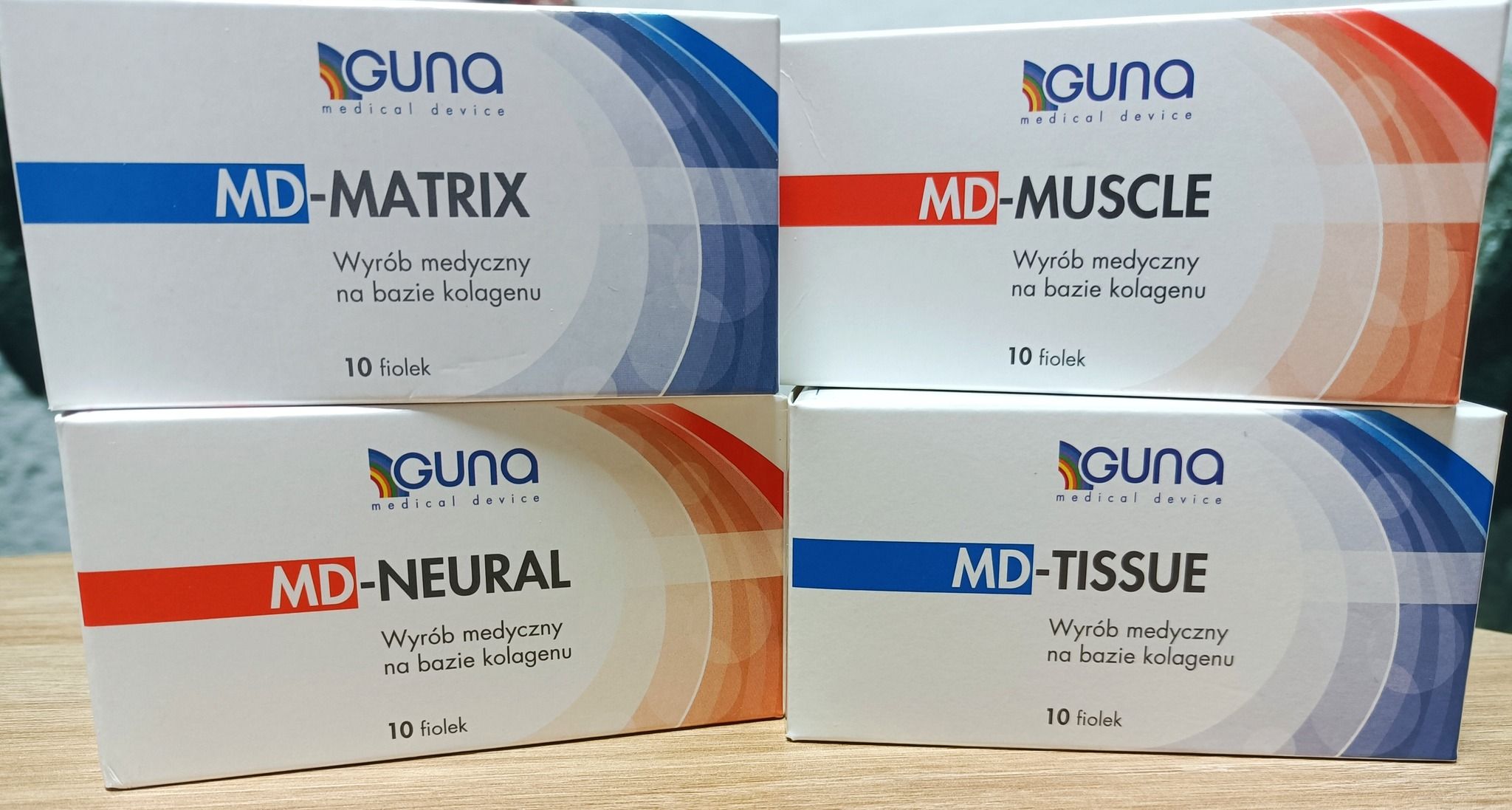 Cztery opakowania wyrobów medycznych Guna na bazie kolagenu: MD-MATRIX, MD-MUSCLE, MD-NEURAL i MD-TISSUE, każde zawiera 10 fiolek