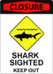 Shark Closure Icon A sign with bold red text at the top that says "Closure" and iconography depicting a shark swimming near the beach. At the bottom of the sign there is text that says: "Shark sighted. Keep out."