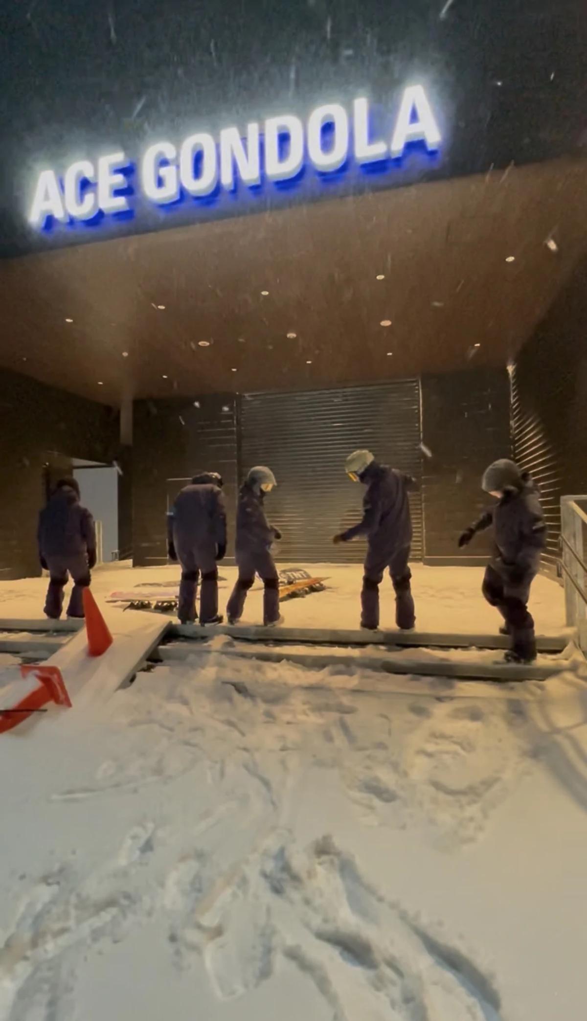 夜滑時段的 Ace Gondola 站,雪還在下,一群人在門口穿裝備