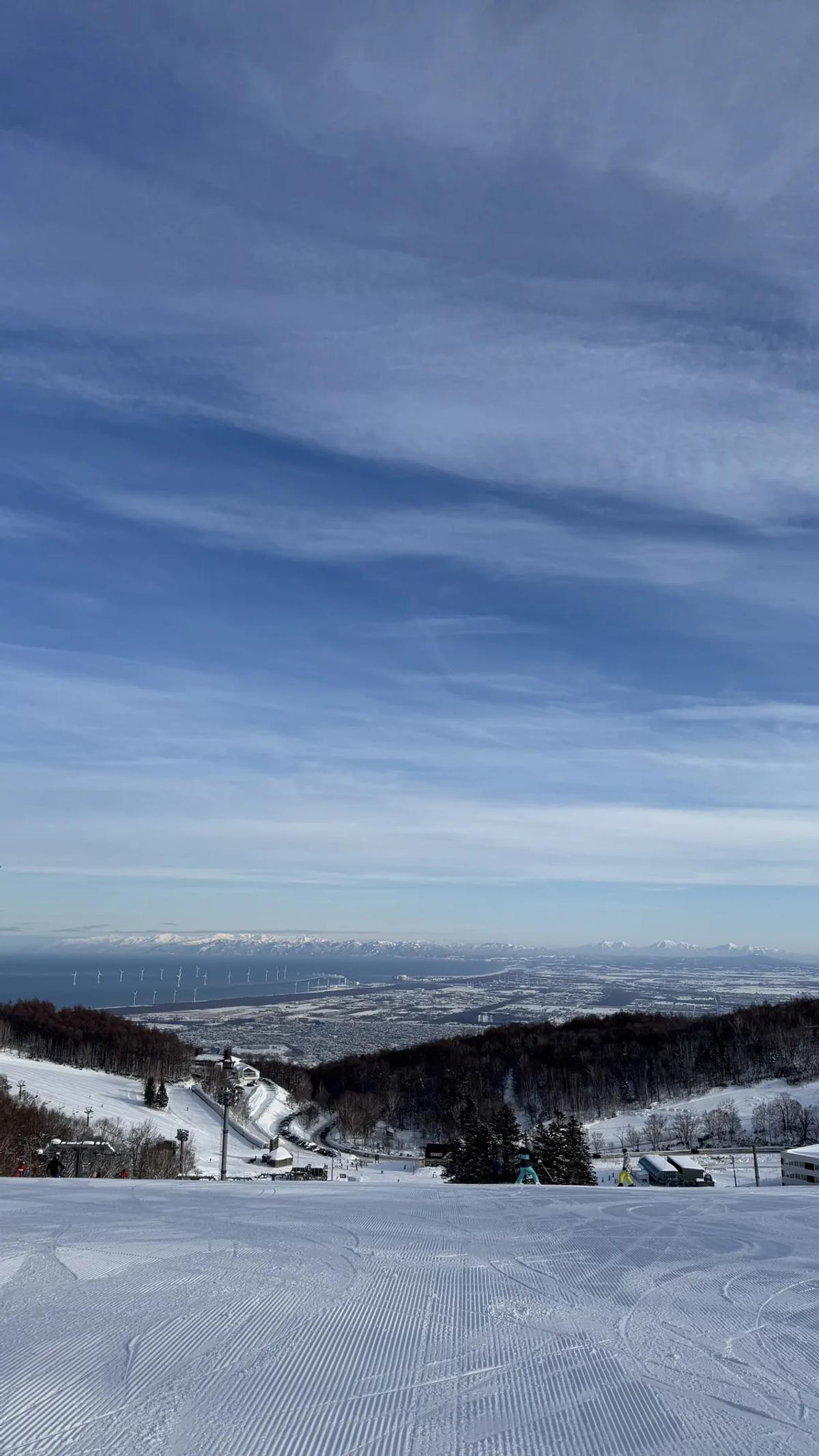 手稻雪道頂端望向札幌平原與海岸線,天空有絲狀高雲