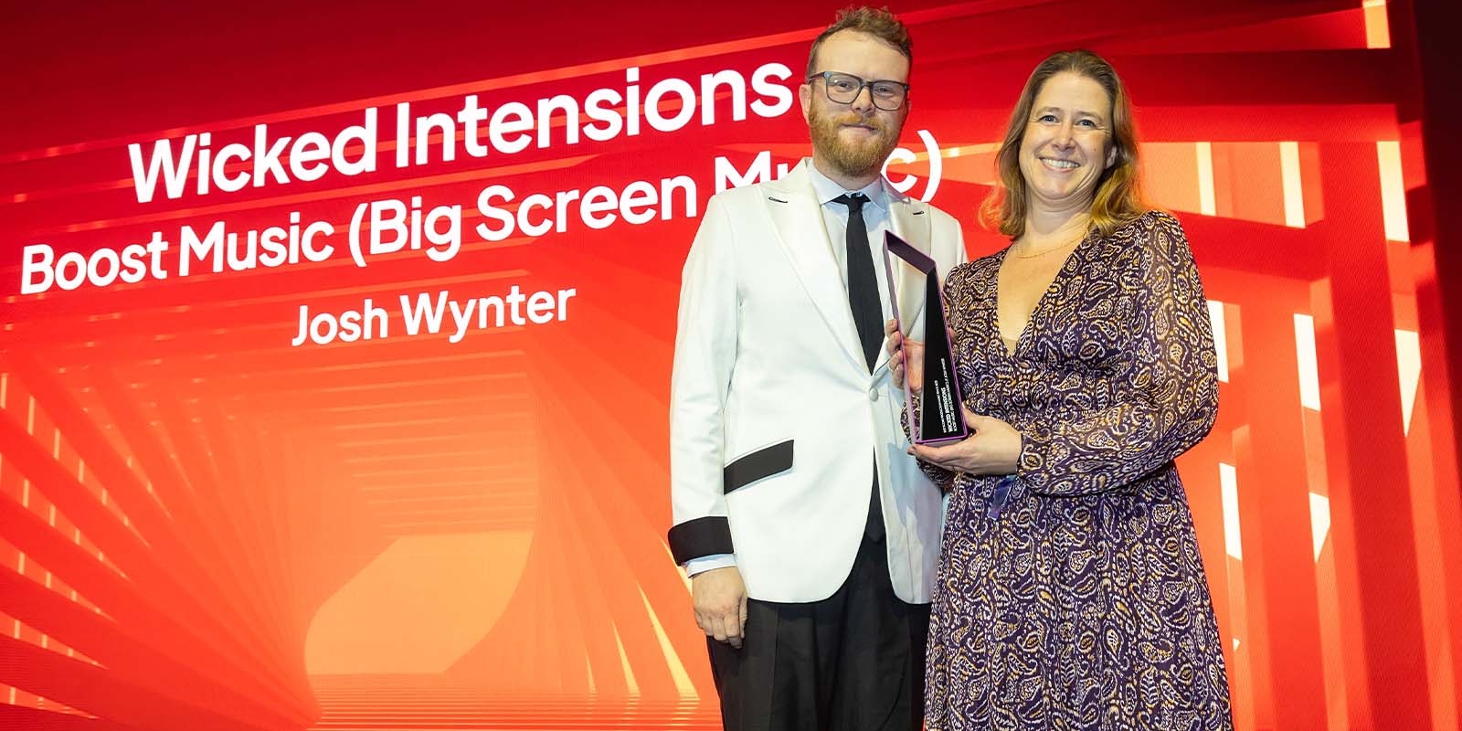 Big Screen Music's Olivia Dixon with Huw Stephens at the Production Music Awards 2023, collecting the award for Best Score