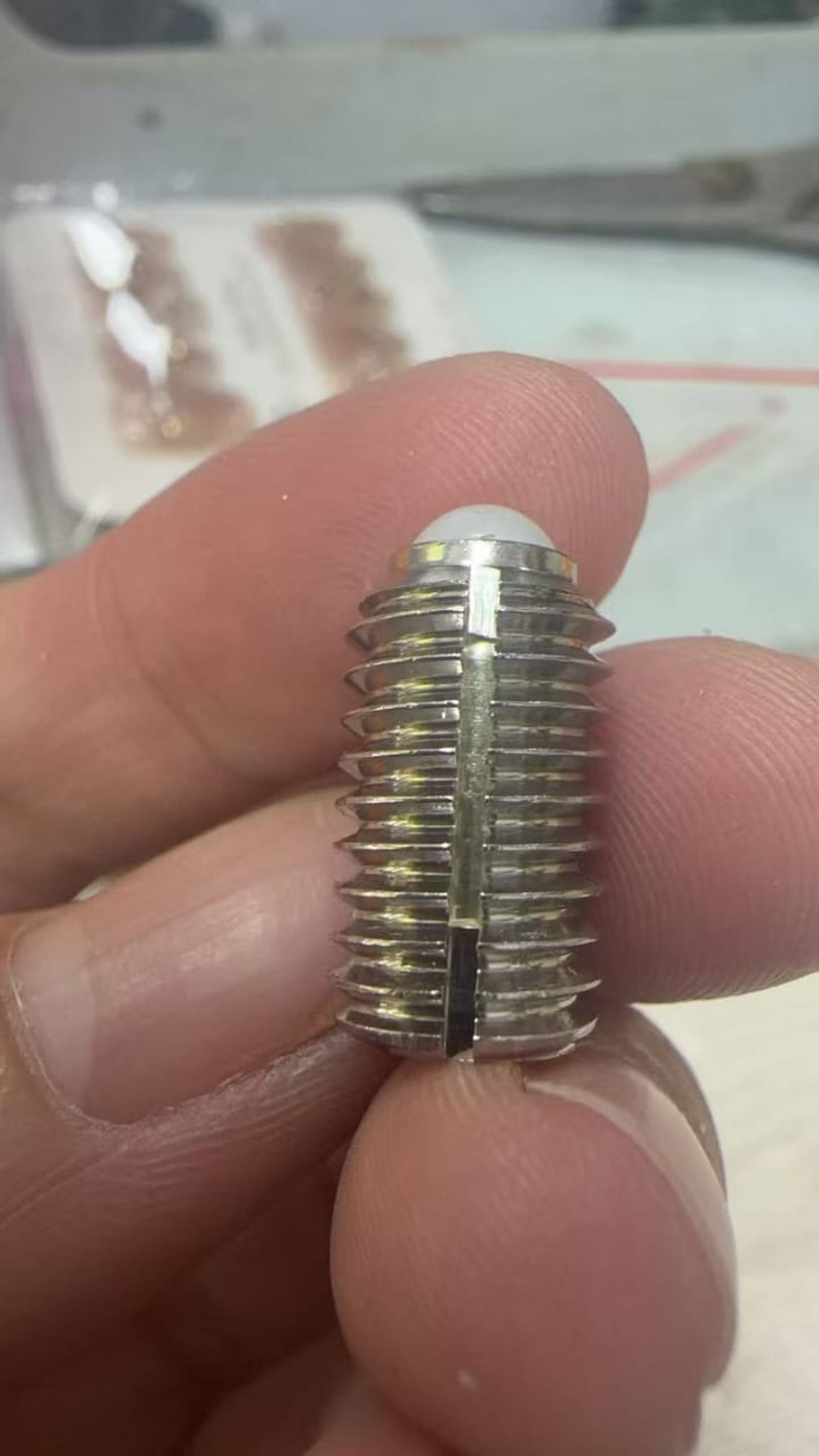 Close-up of a custom SS304 ball plunger screw with a white polymer ball tip