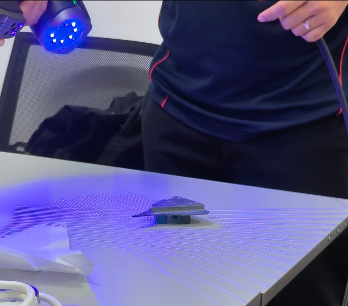 Handheld structured-light scanner capturing a small industrial component