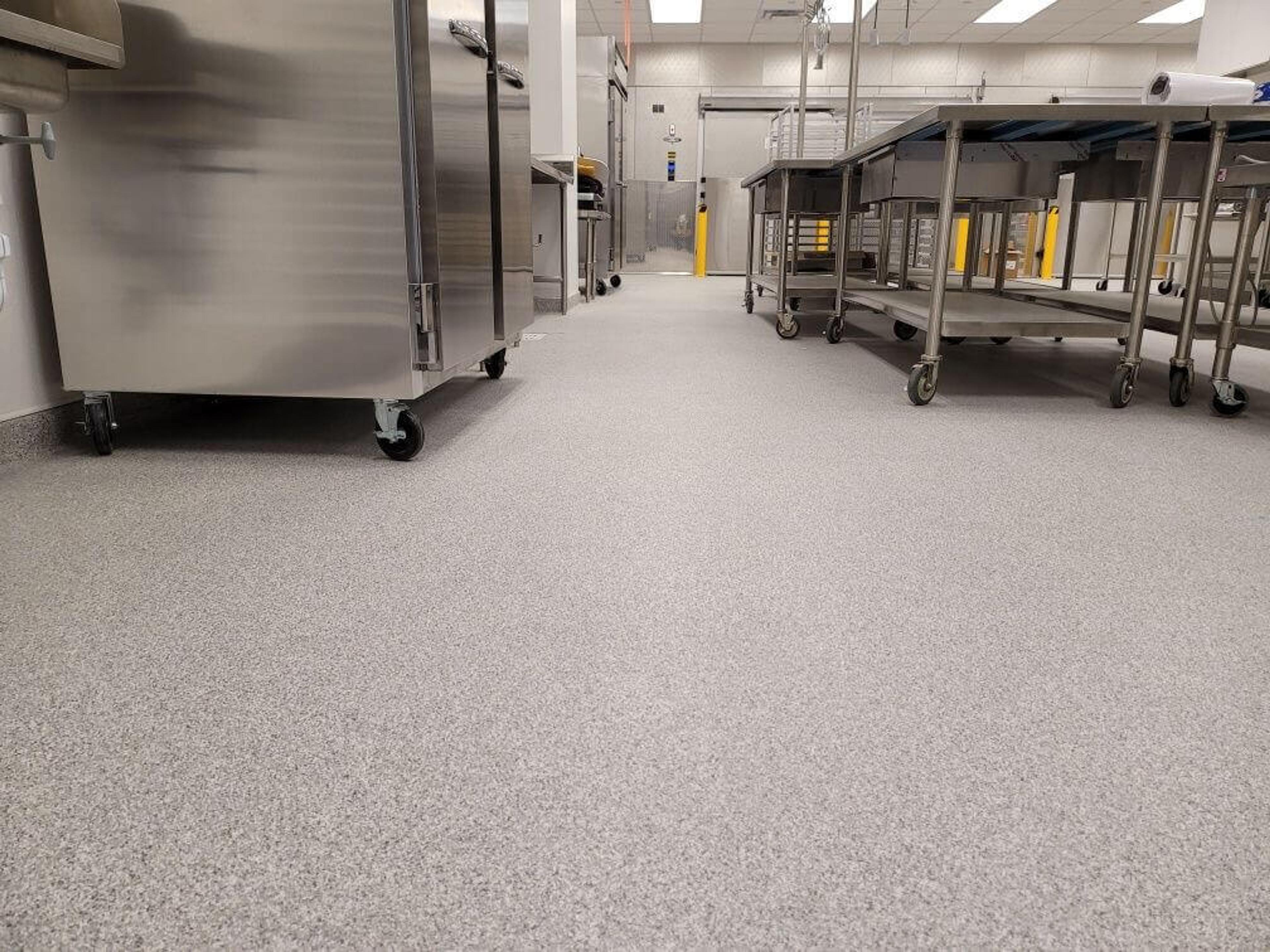 Speckled flake epoxy floor in a commercial kitchen with stainless steel tables