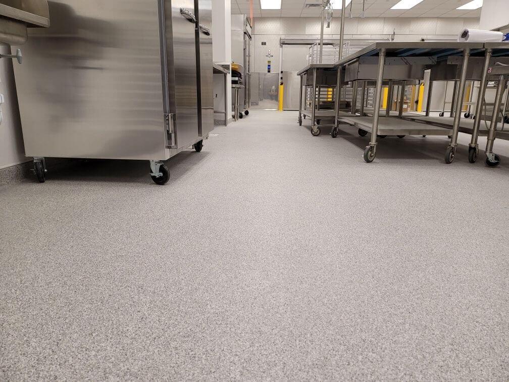 Speckled flake epoxy floor in a commercial kitchen with stainless steel tables