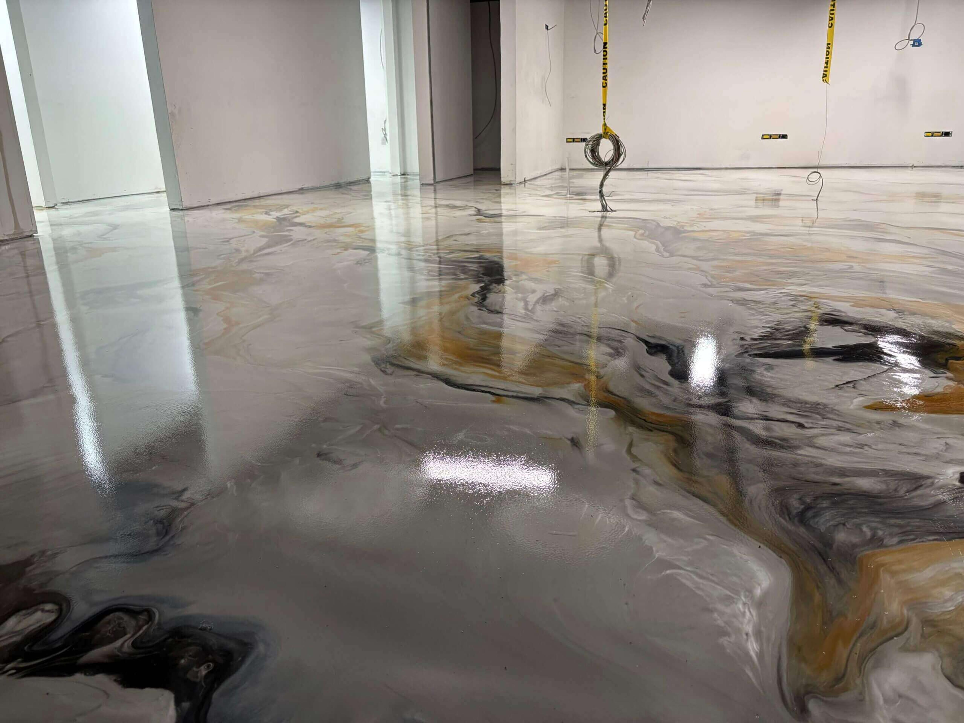 Metallic epoxy floor with swirling gray, white, and gold marbling