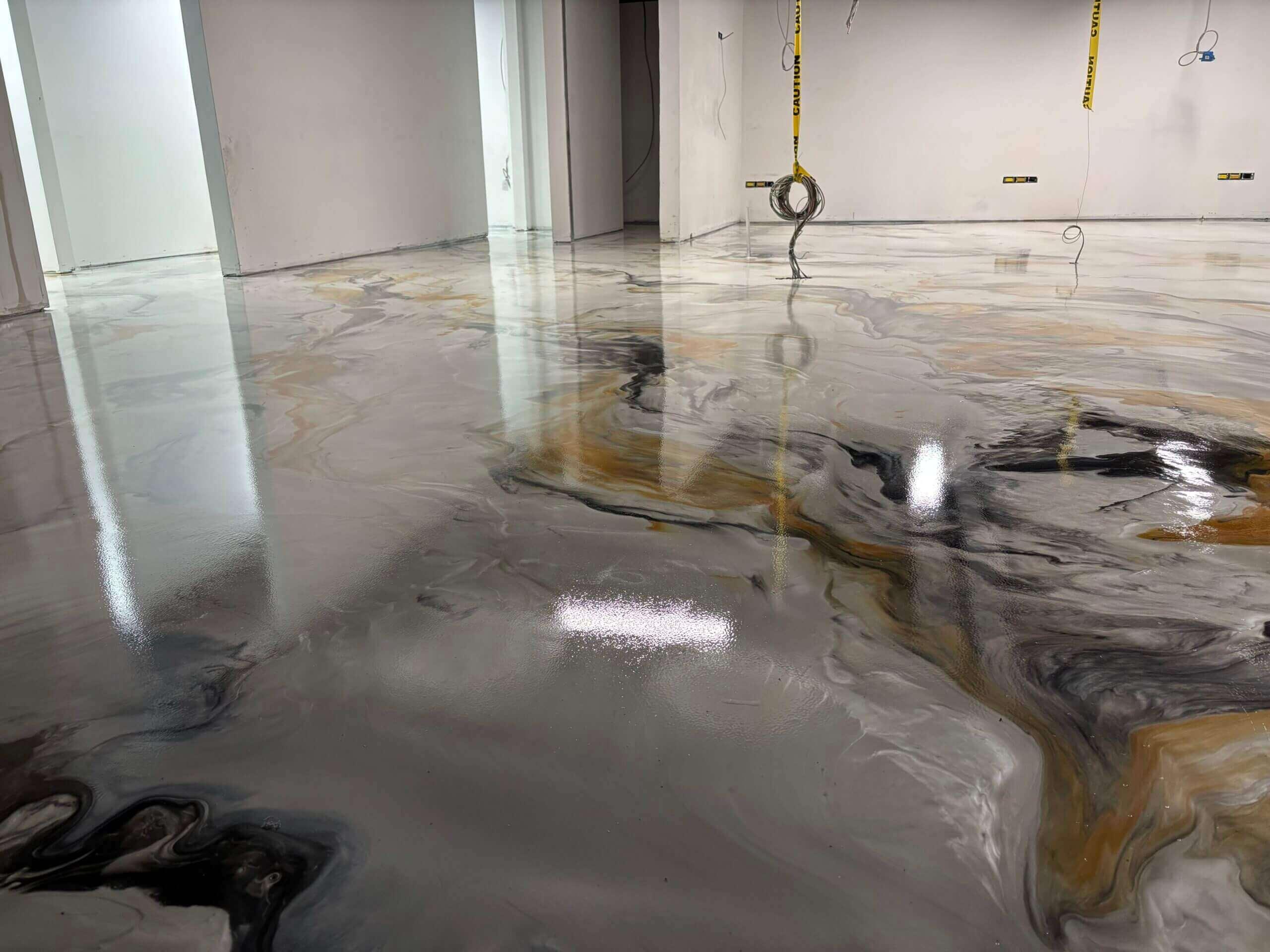 Metallic epoxy floor with swirling gray, white, and gold marbling