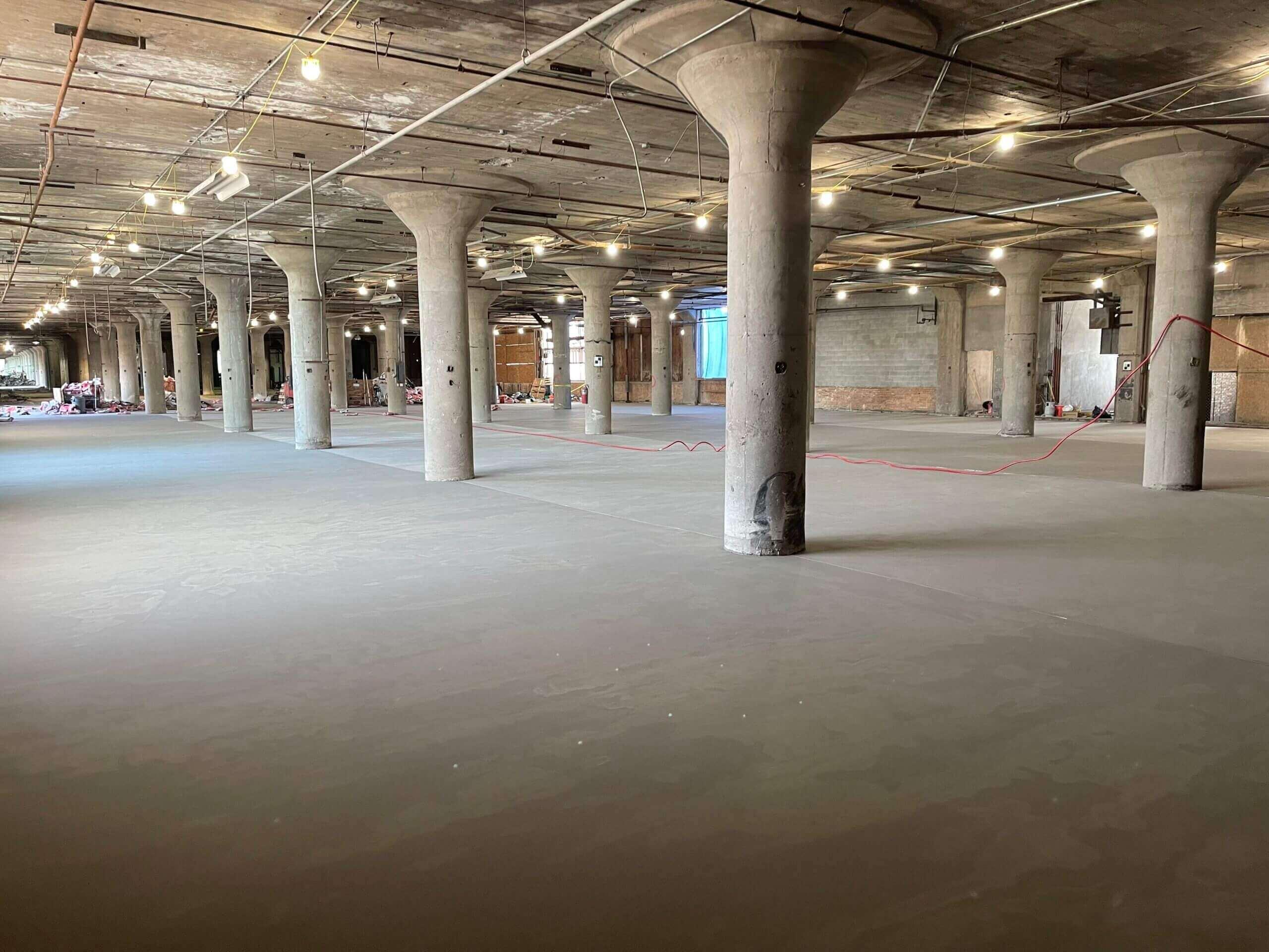 Leveled concrete floor in a large industrial building with mushroom columns