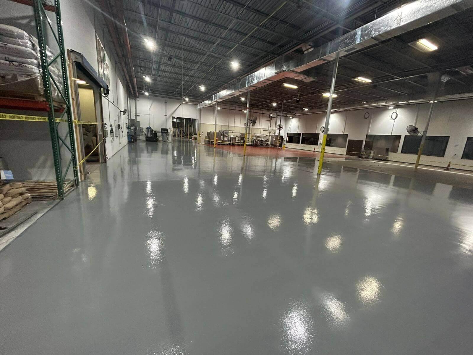 Glossy gray epoxy floor in a manufacturing warehouse