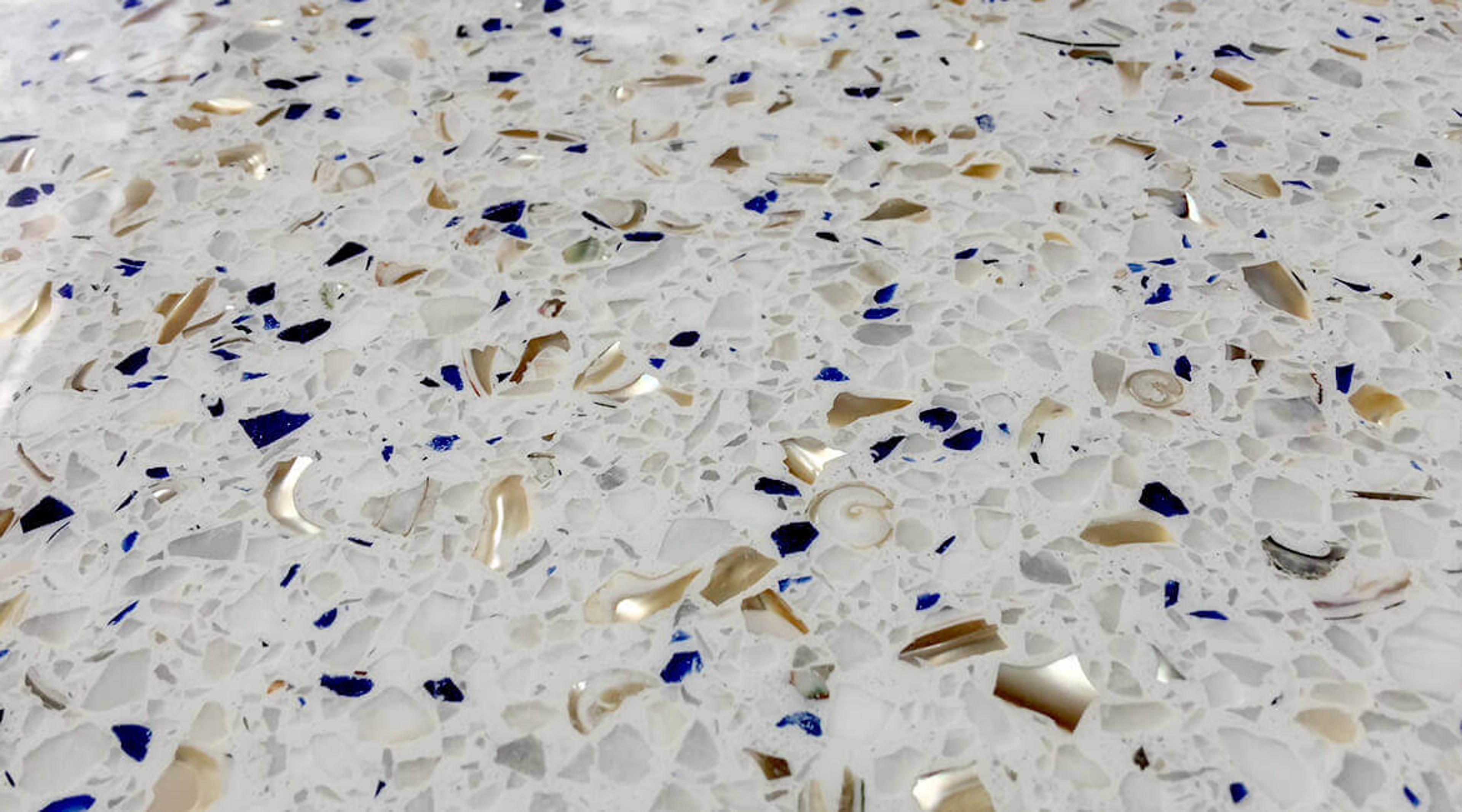 Close-up of white terrazzo with blue glass and gold aggregate