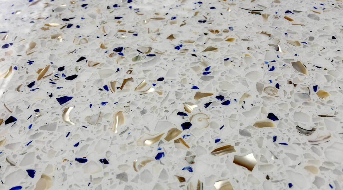 Close-up of white terrazzo with blue glass and gold aggregate