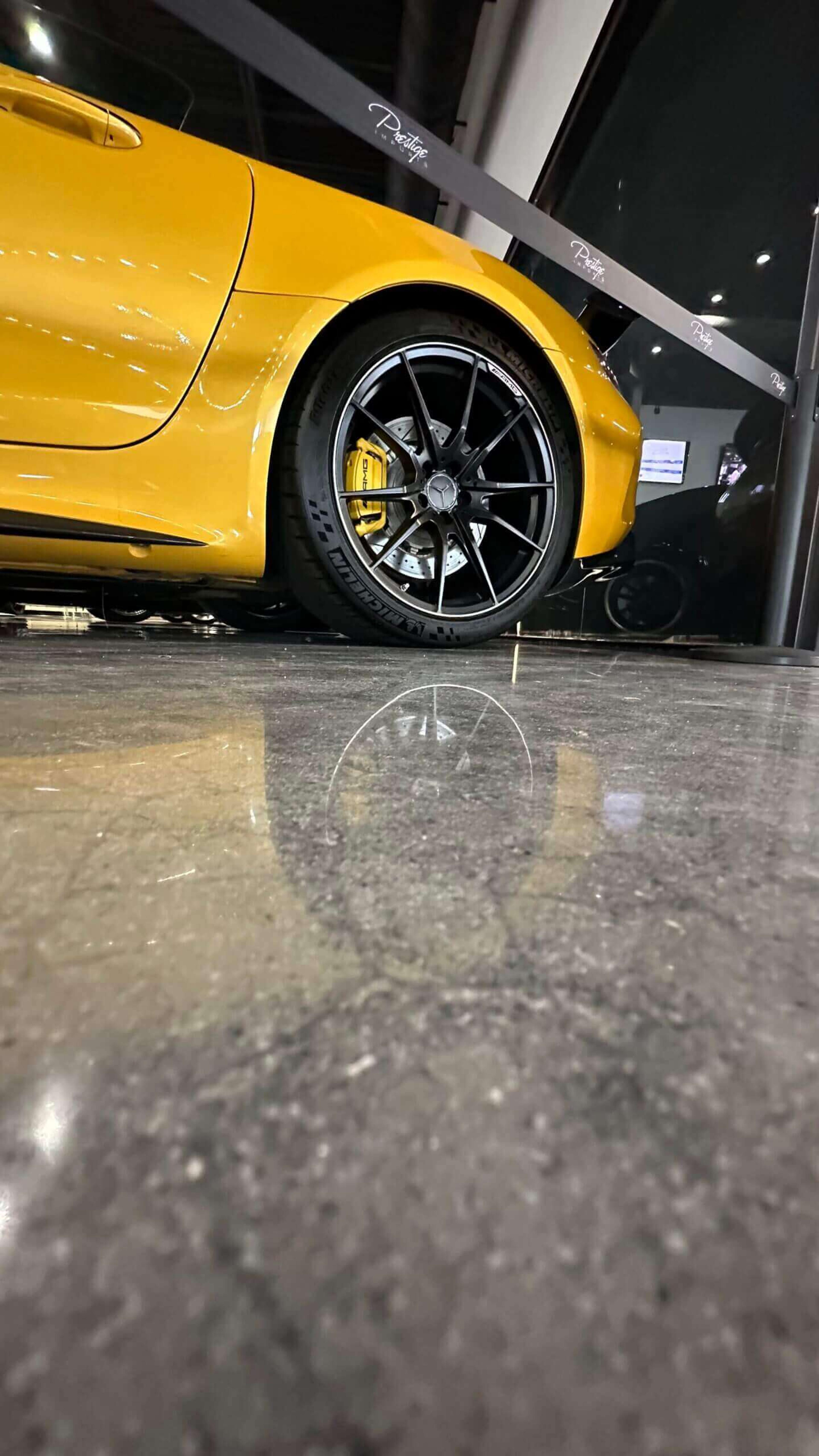 Polished concrete floor reflecting a yellow sports car