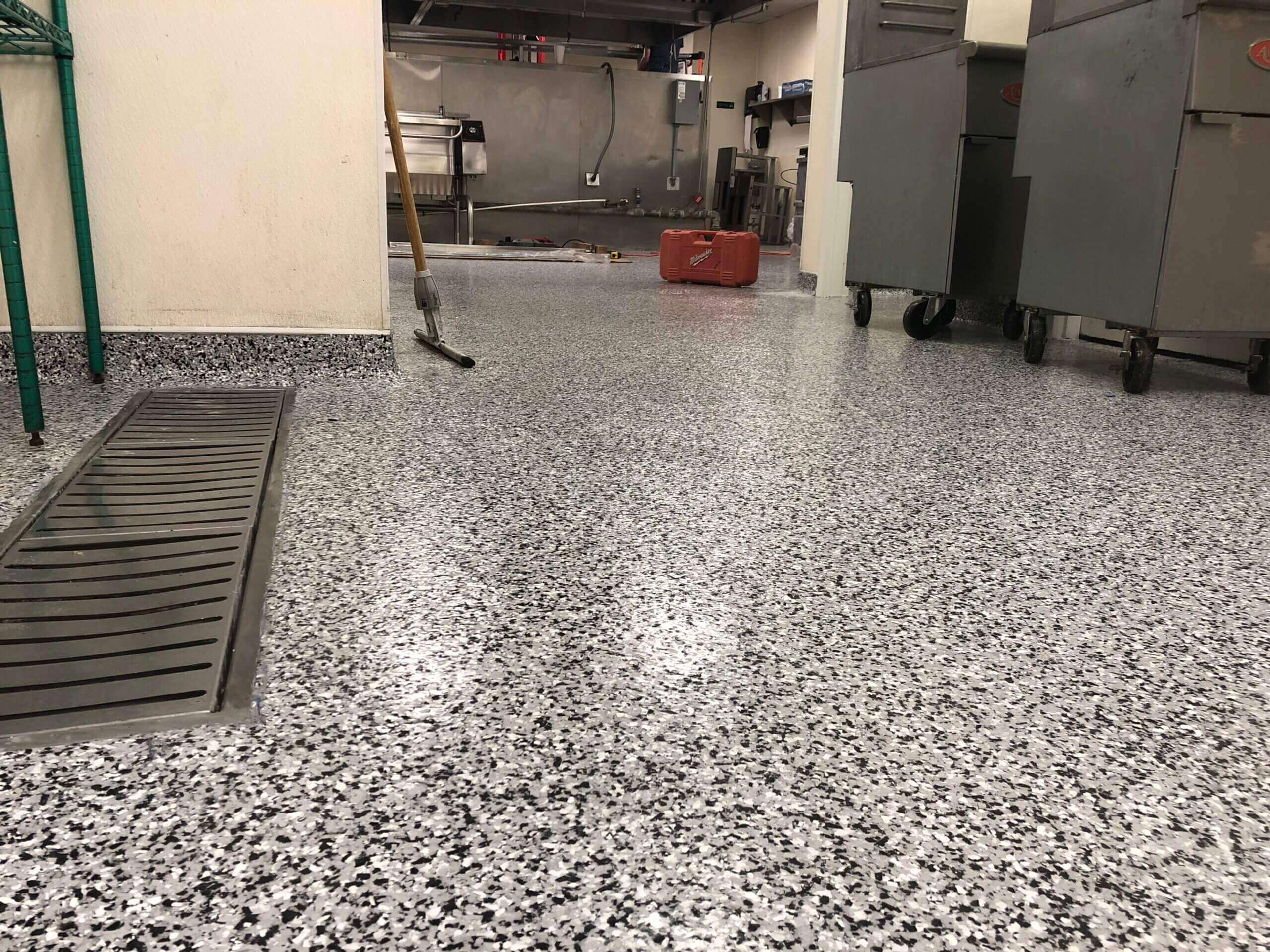 Speckled flake epoxy floor with a trench drain in a commercial kitchen
