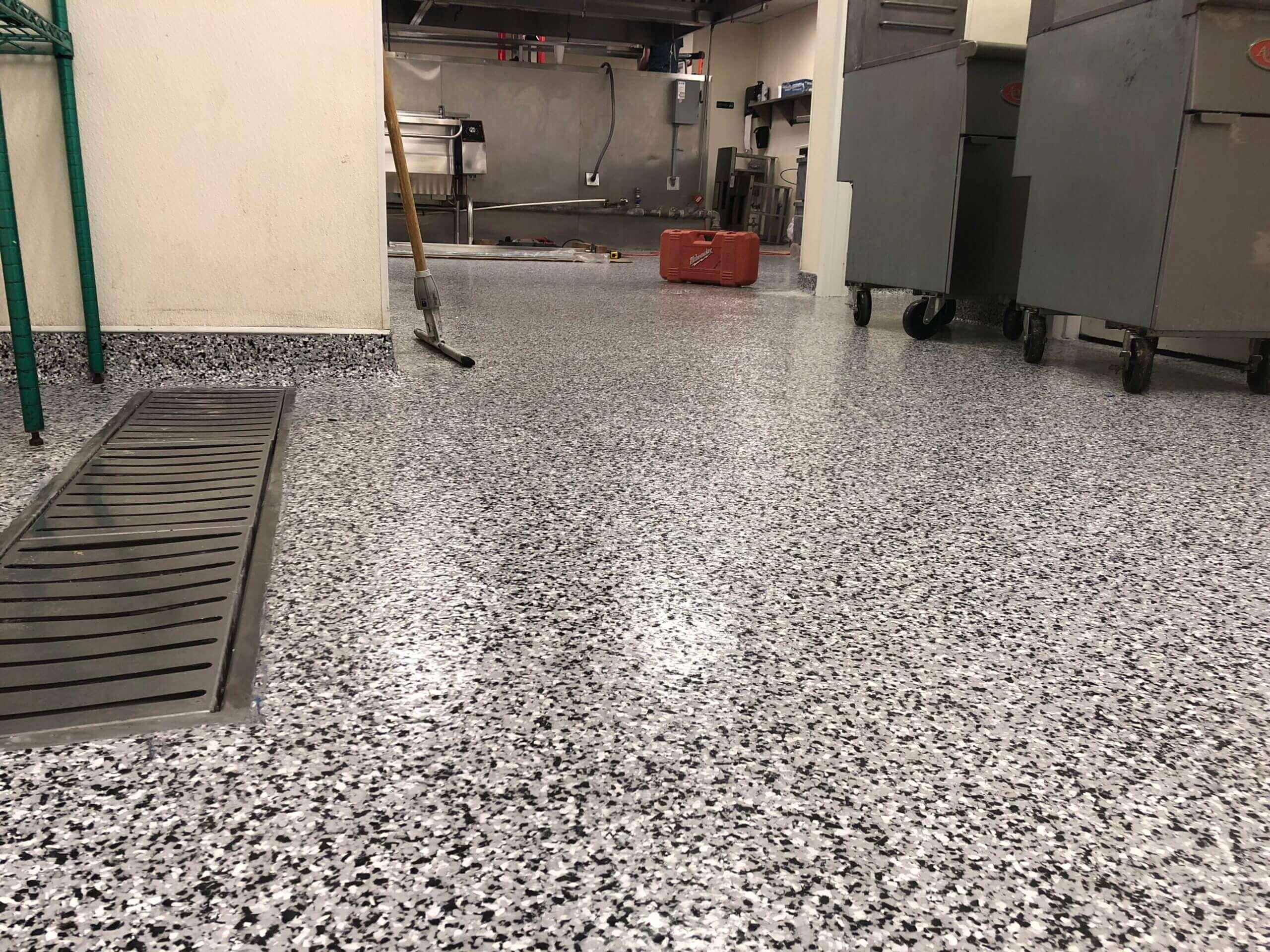 Speckled flake epoxy floor with a trench drain in a commercial kitchen
