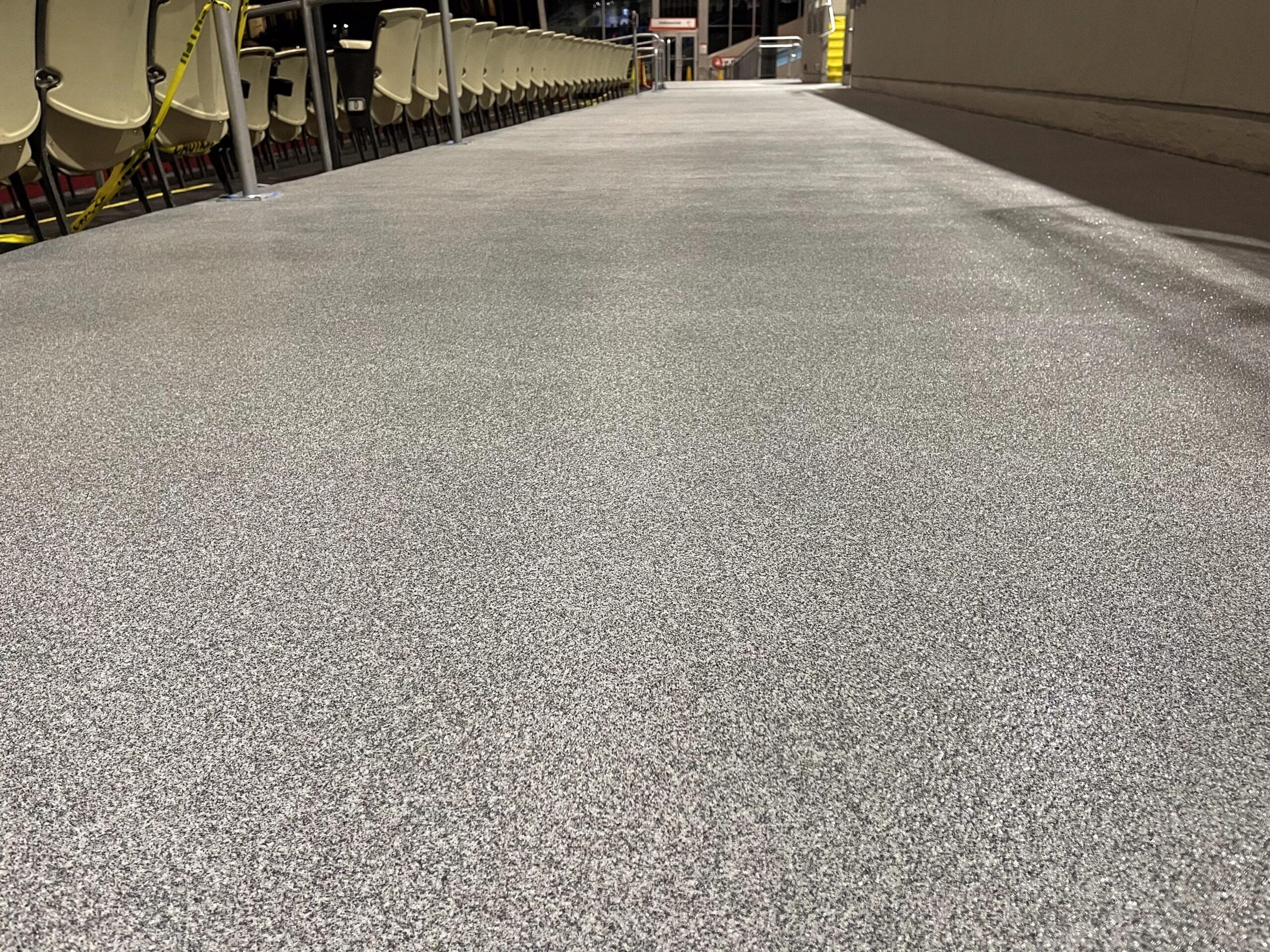 Speckled floor coating along a long facility concourse
