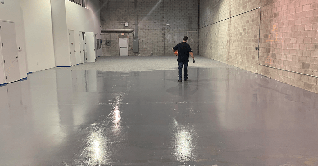 Glossy gray epoxy floor in an empty warehouse bay