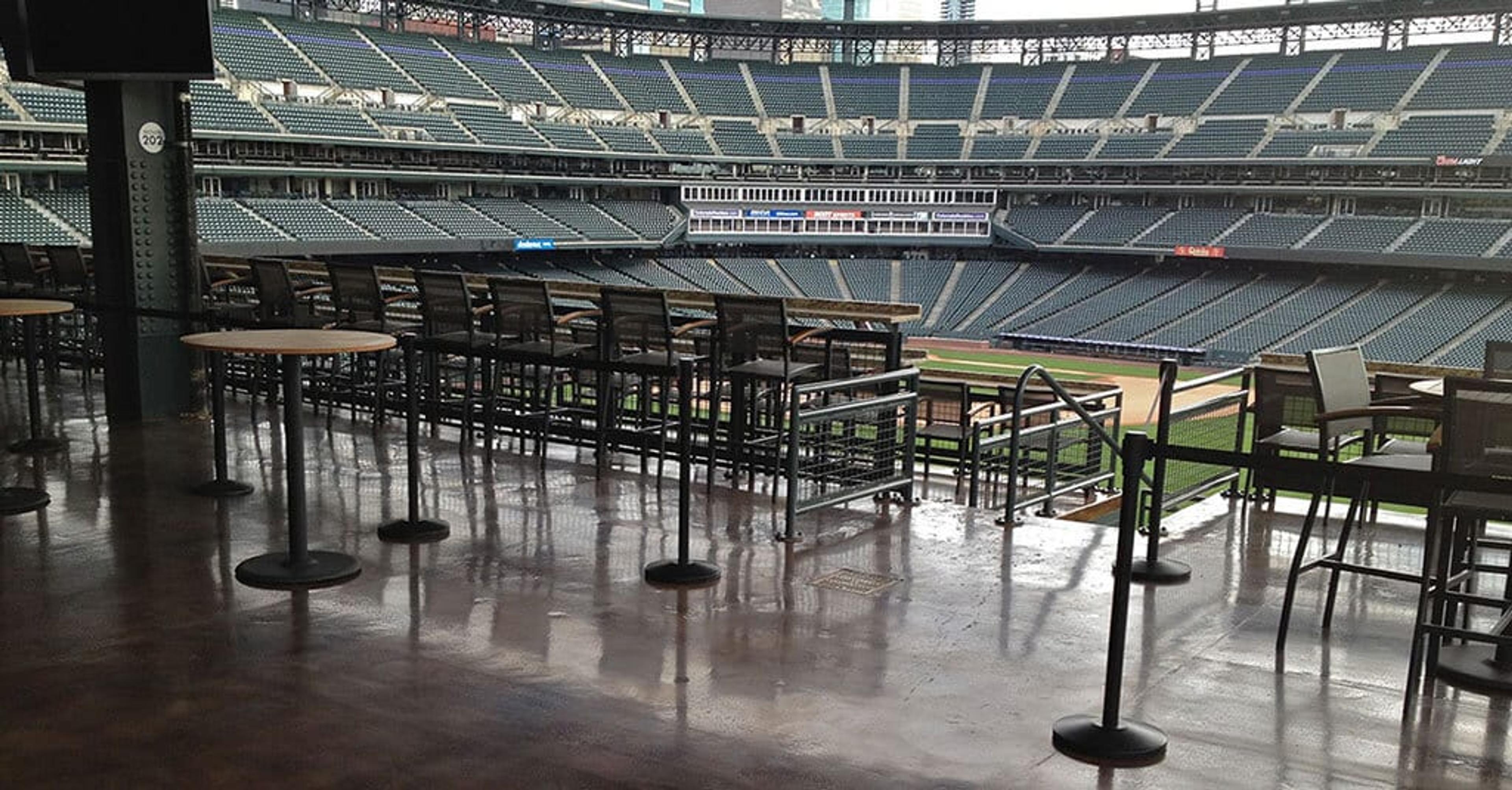 Sealed concrete floor on a stadium club level overlooking a baseball field