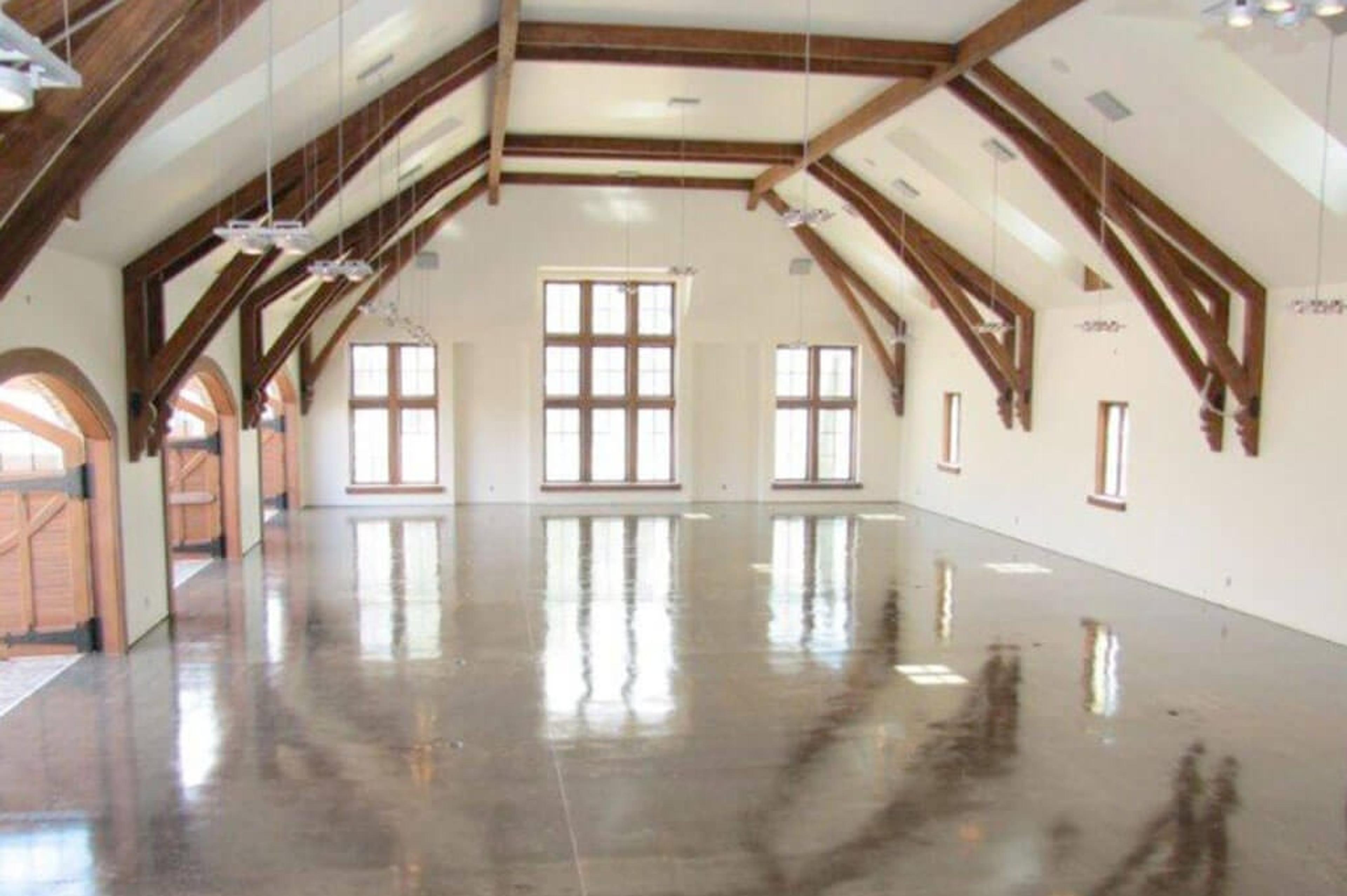 Metallic epoxy floor in a vaulted hall with exposed timber trusses