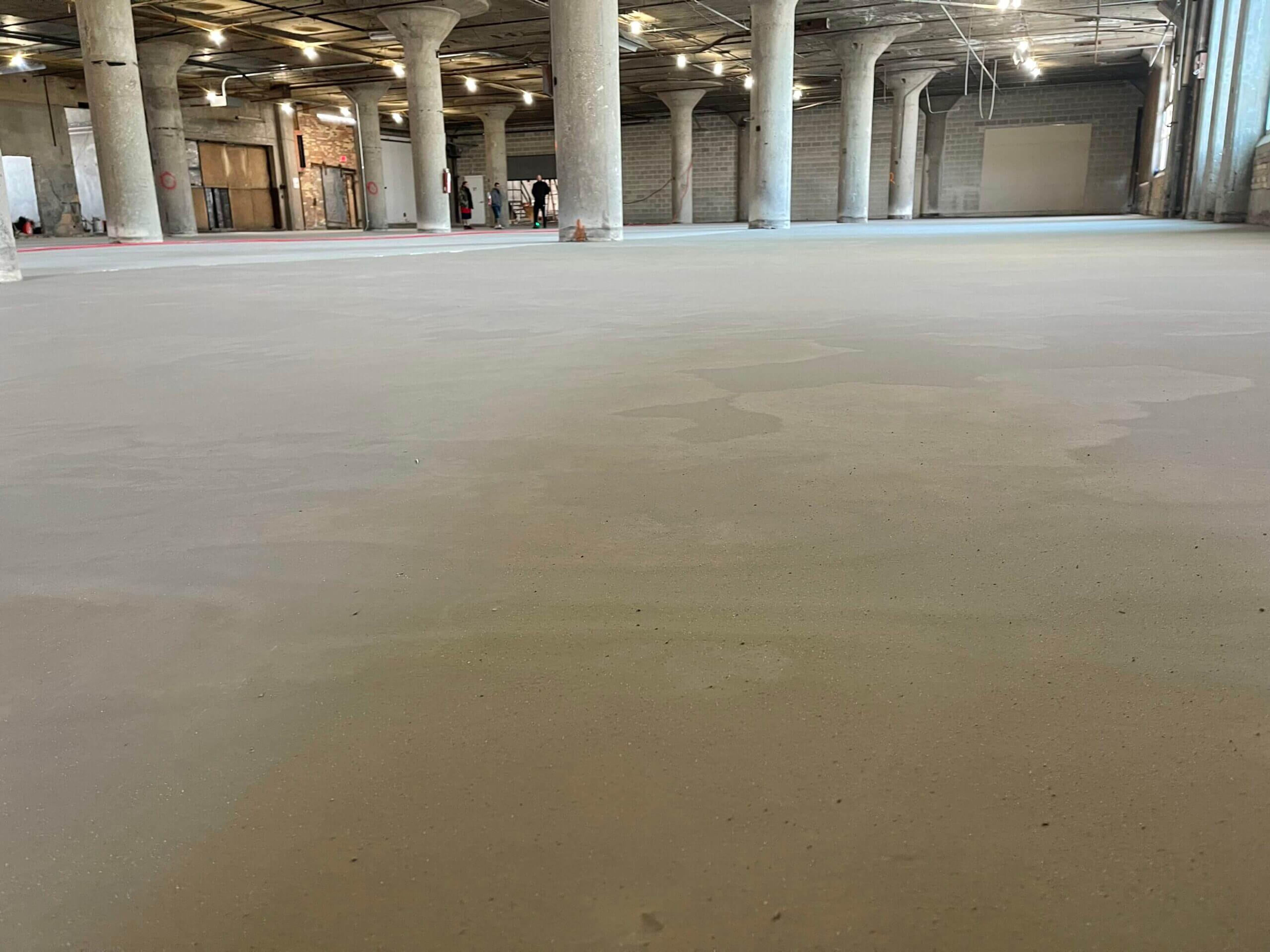Prepared concrete floor ready for resurfacing in a large building with columns
