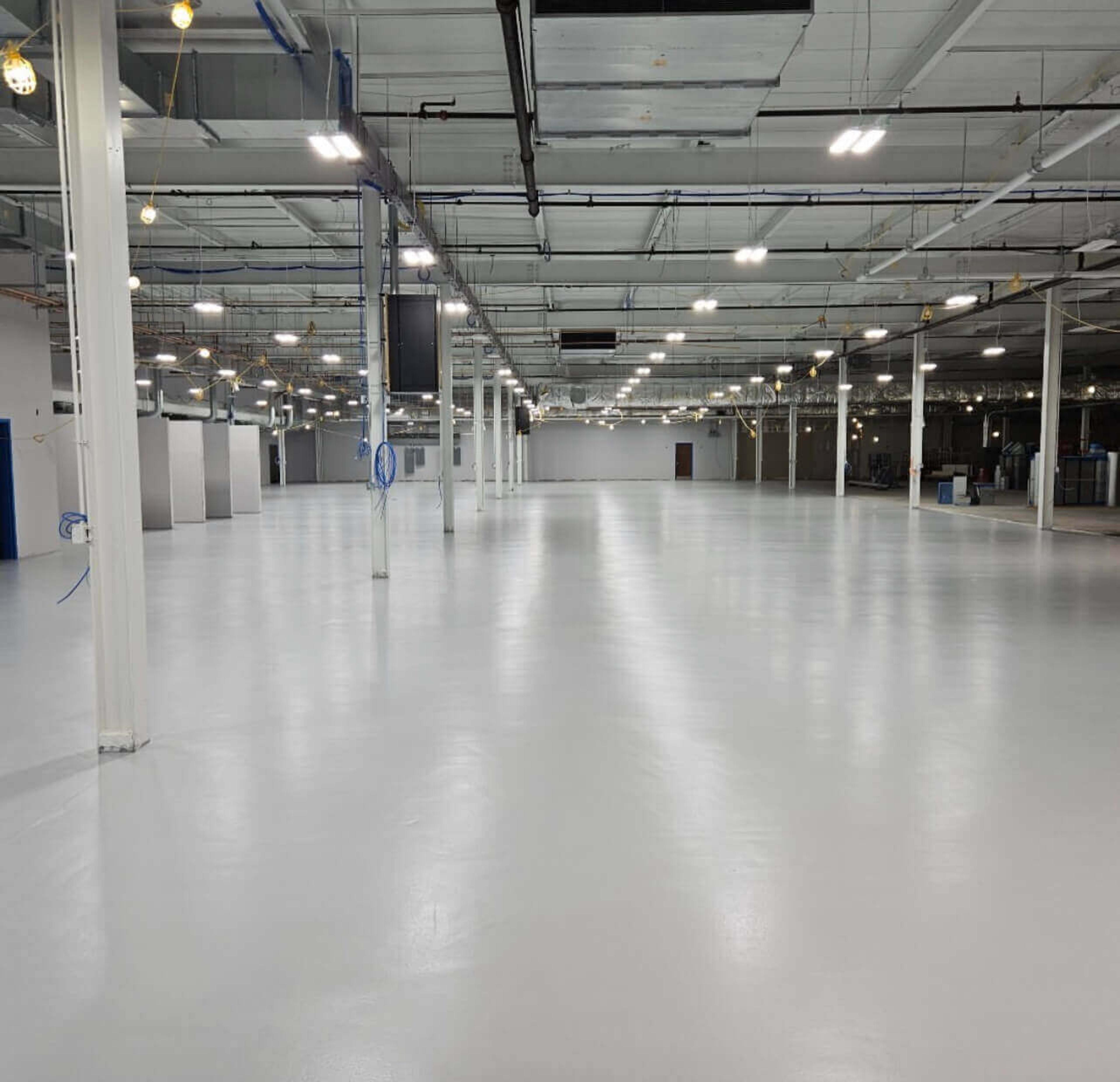 Glossy white epoxy floor in a large industrial facility